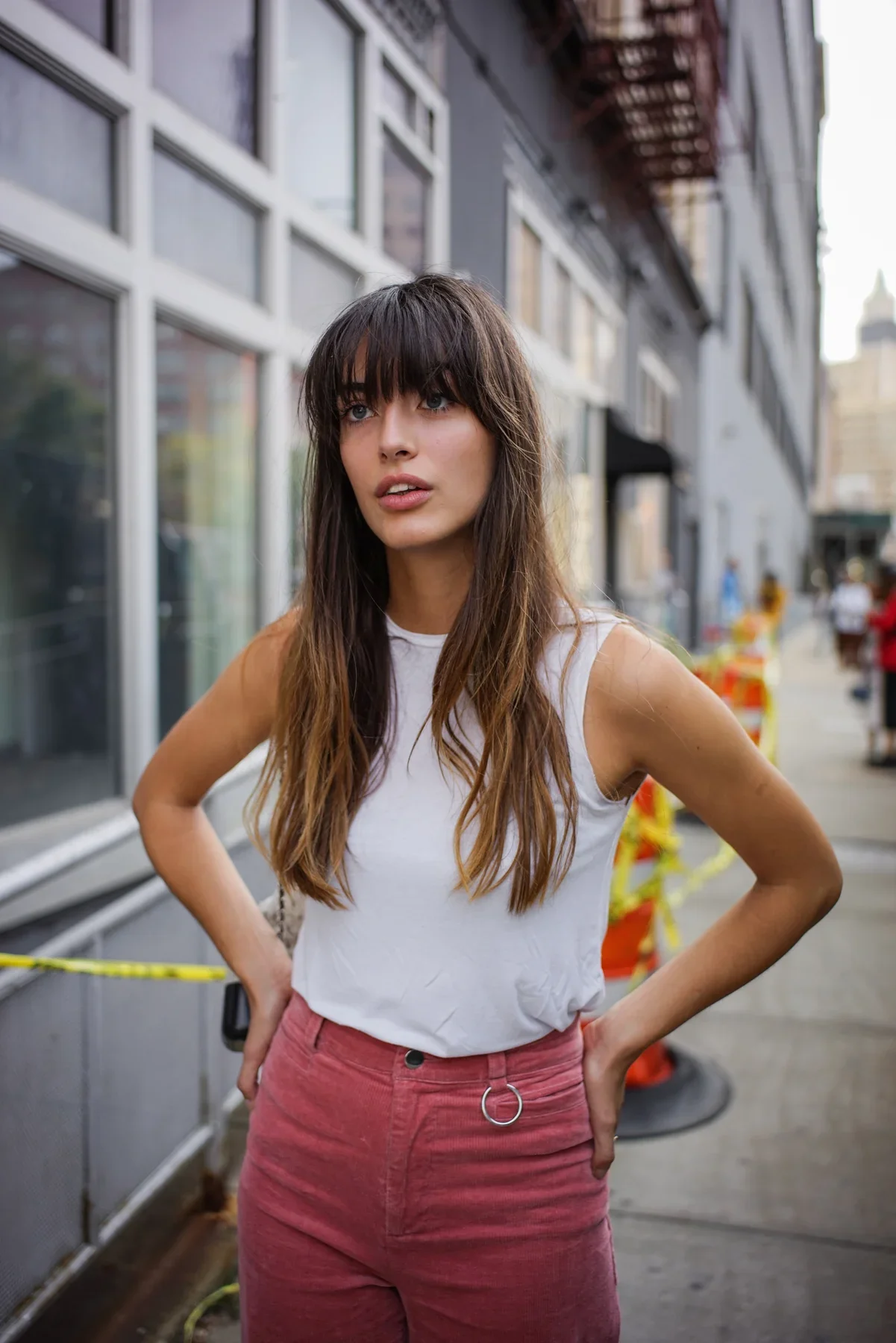 Full-color editorial street style portrait of model Louise Follain (@louisefollain) during New York Fashion Week (NYFW) in NYC. Photographed by Leonard 'Lenny Kats' Katsel, featuring urban fashion styling with a white tank top and pink corduroy pants