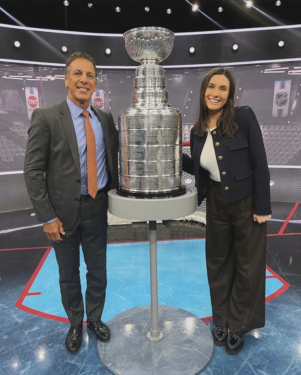 Grace Johnson and NHL Hall of Famer Chris Chelios holding the Stanley Cup hockey trophy on the NHL on TNT set, highlighting Grace's experience supporting elite athletes and sports professionals.