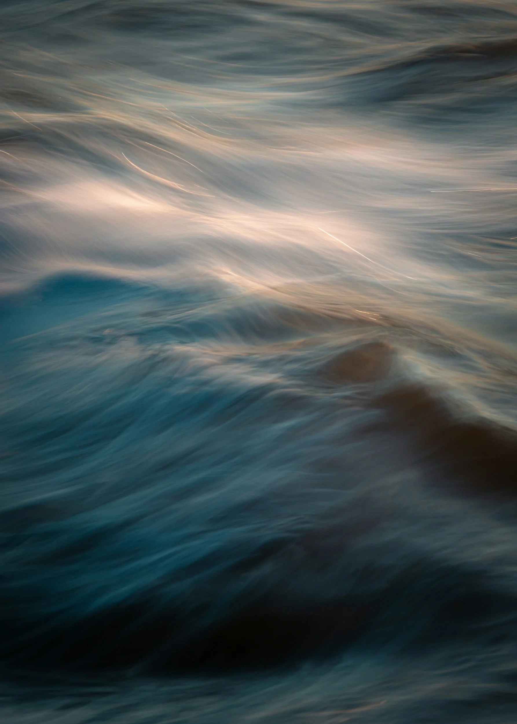Vague d'eau en mouvement avec des reflets de lumière, évoquant la mer ou un océan en surface.