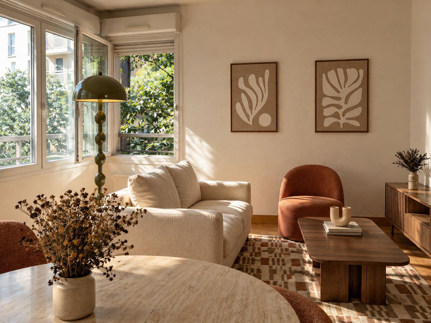 Salon lumineux avec canapé beige, fauteuil terracotta, table basse en bois, décor moderne, plantes et art abstrait sur le mur, grande fenêtre laissant entrer la lumière naturelle.