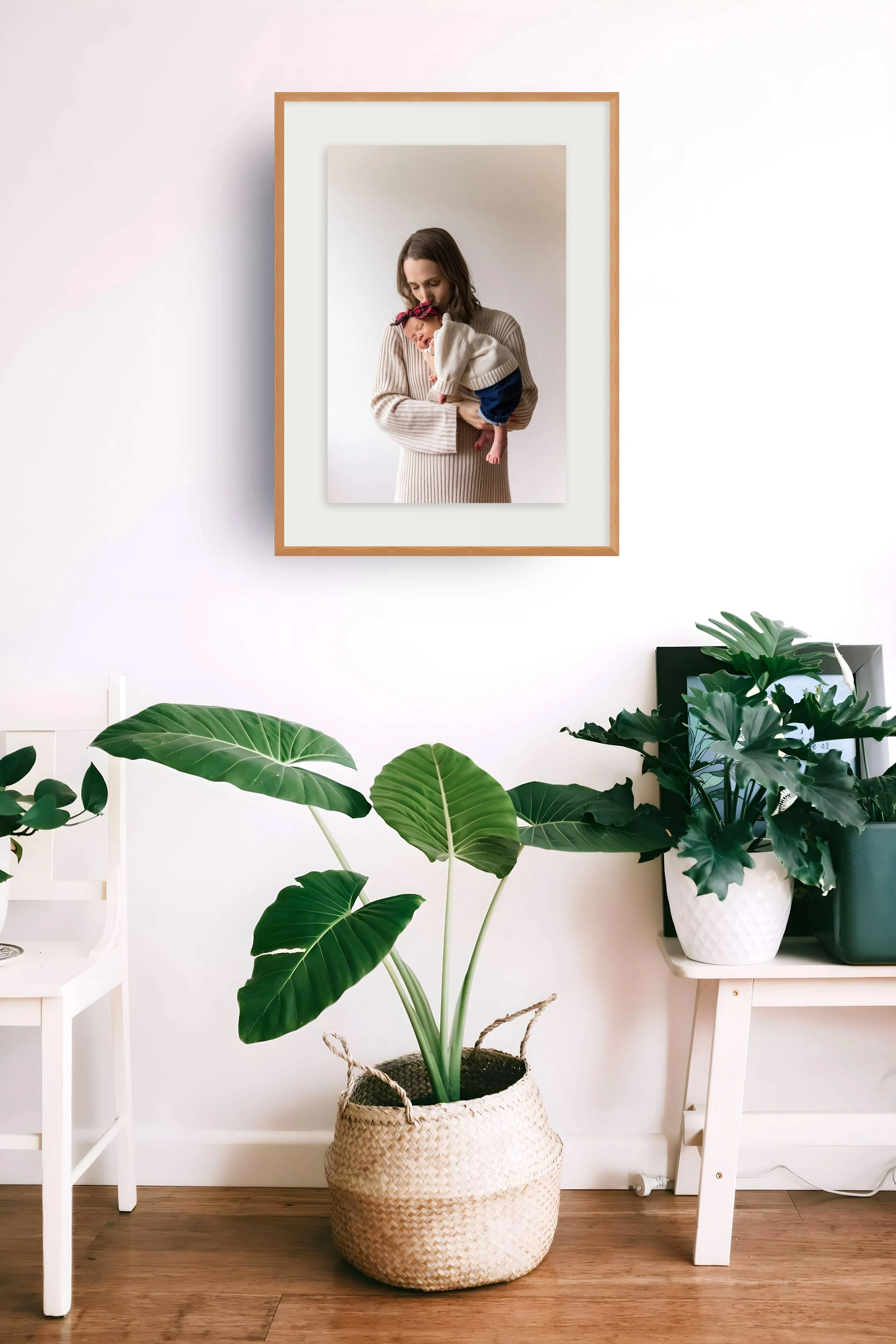 Framed fine art family portrait styled on a wall above a console table with plants — premium wall art for the home