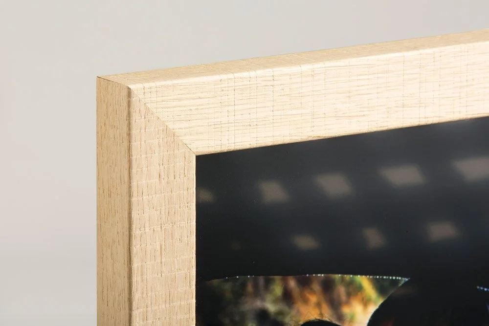 Close-up of natural wood frame corner on a fine art print — premium framed portraits by The Oak Studio