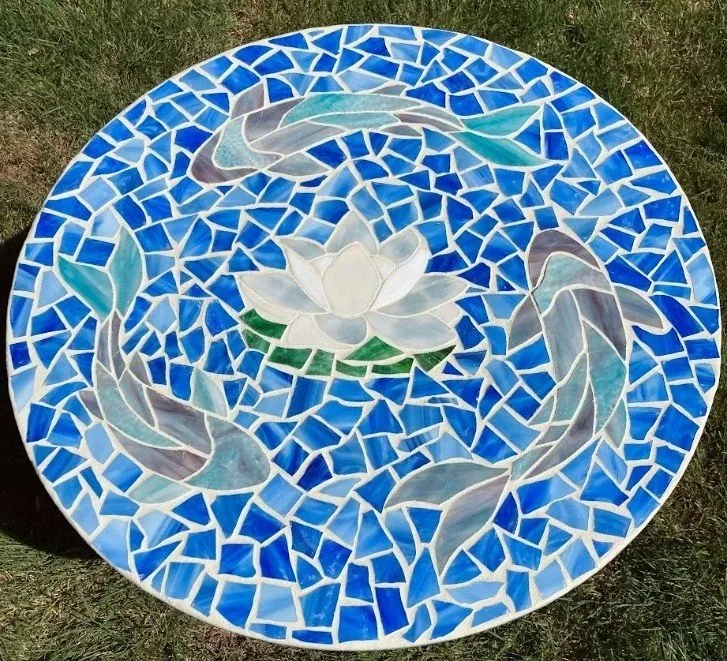 Glass mosaic tabletop featuring three koi surrounding a white water lily. 26" circle. Email for price.