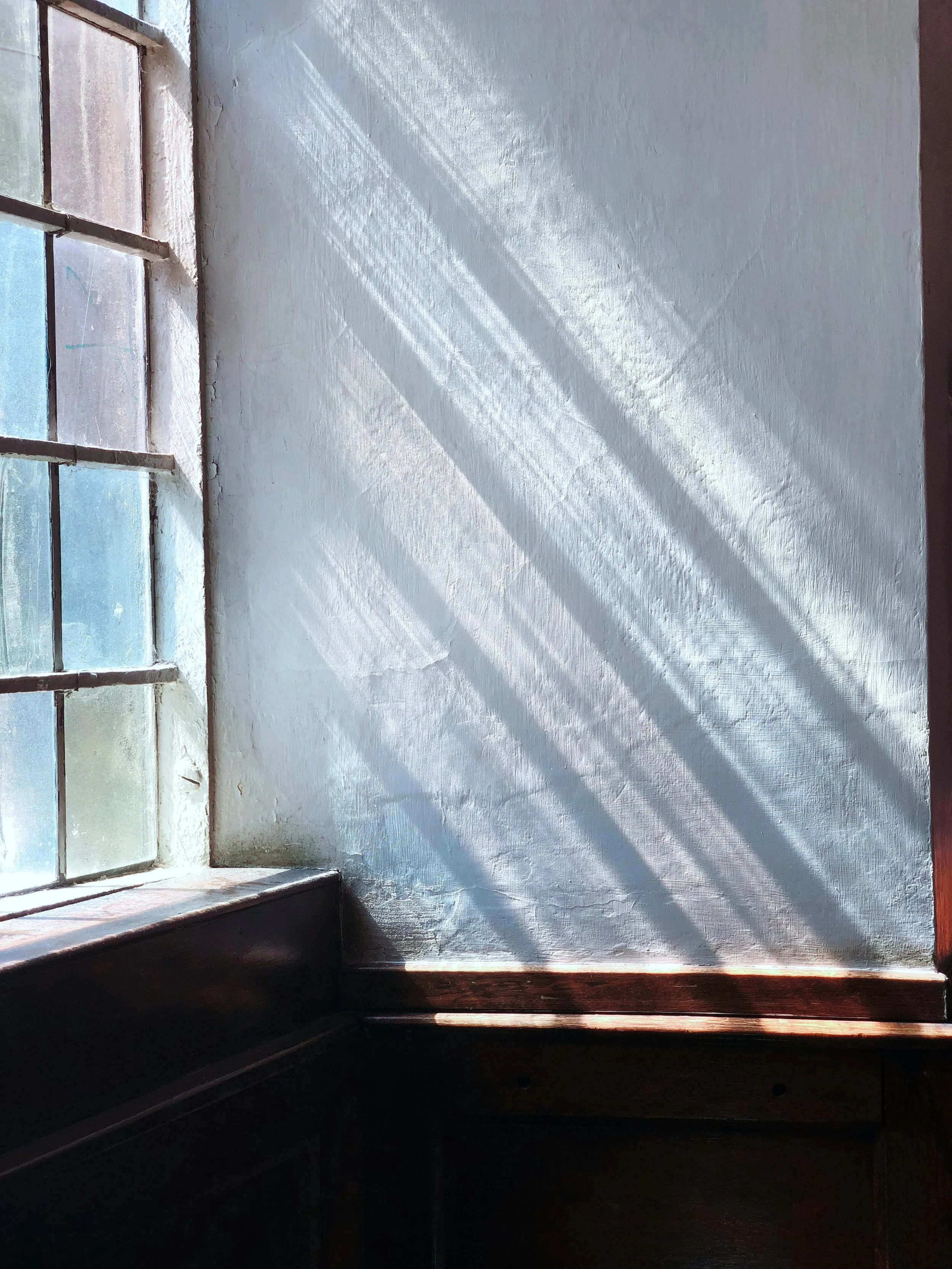 light pouring though a window with square coloured stained glass
