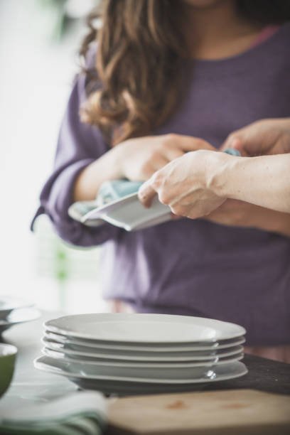 Person cleaning dishes in the kitchen.