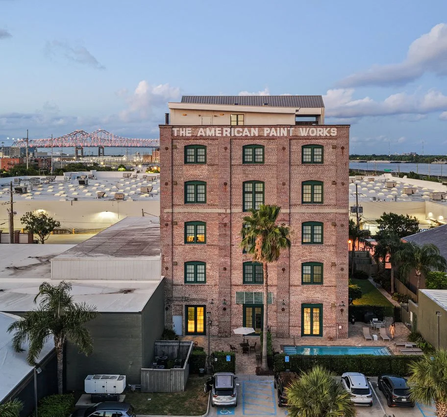 Historic American Paint Works building, home of Josephine Lofts in New Orleans, with the courtyard pool below.