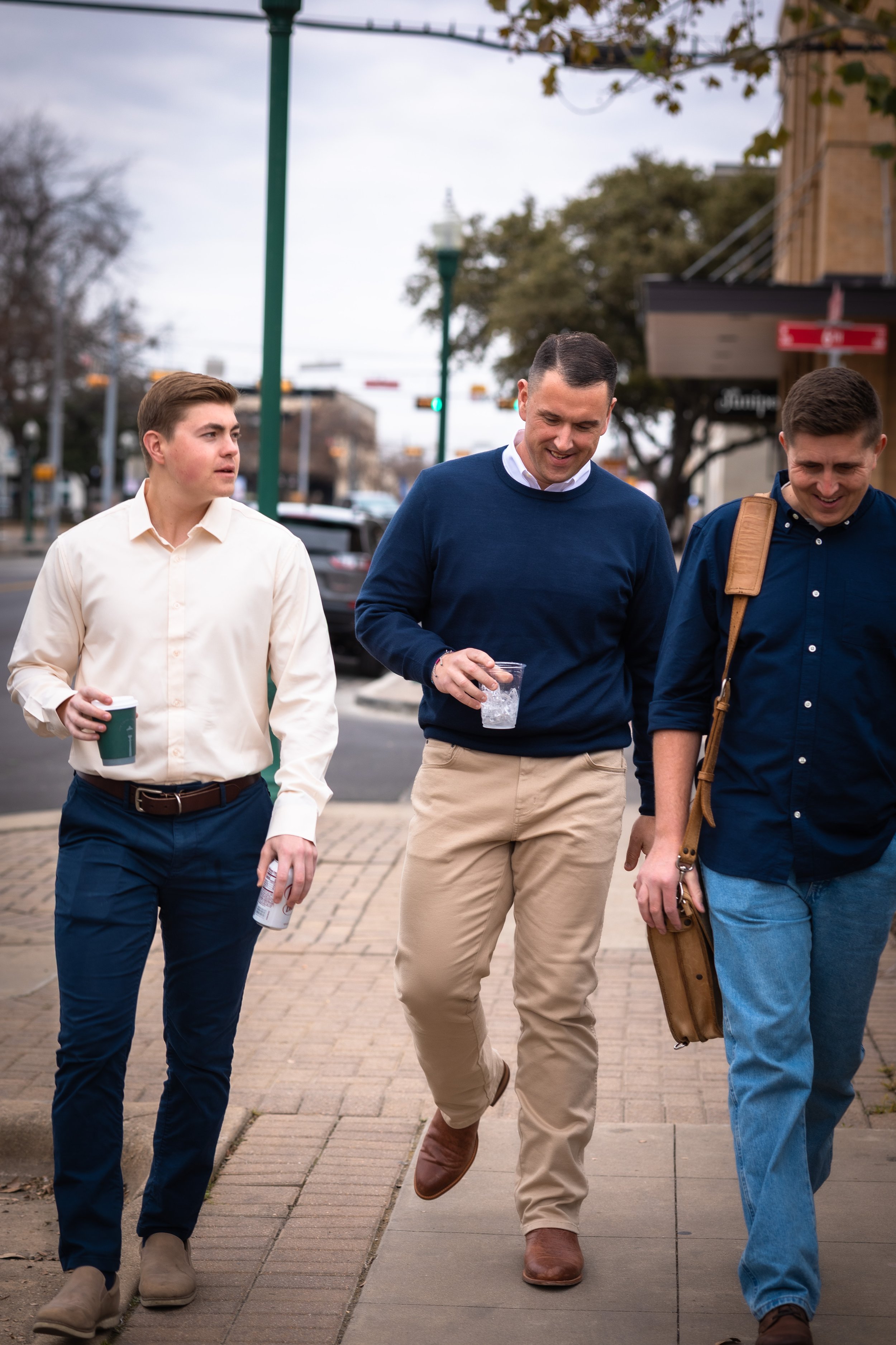 Three men walking down the street chatting