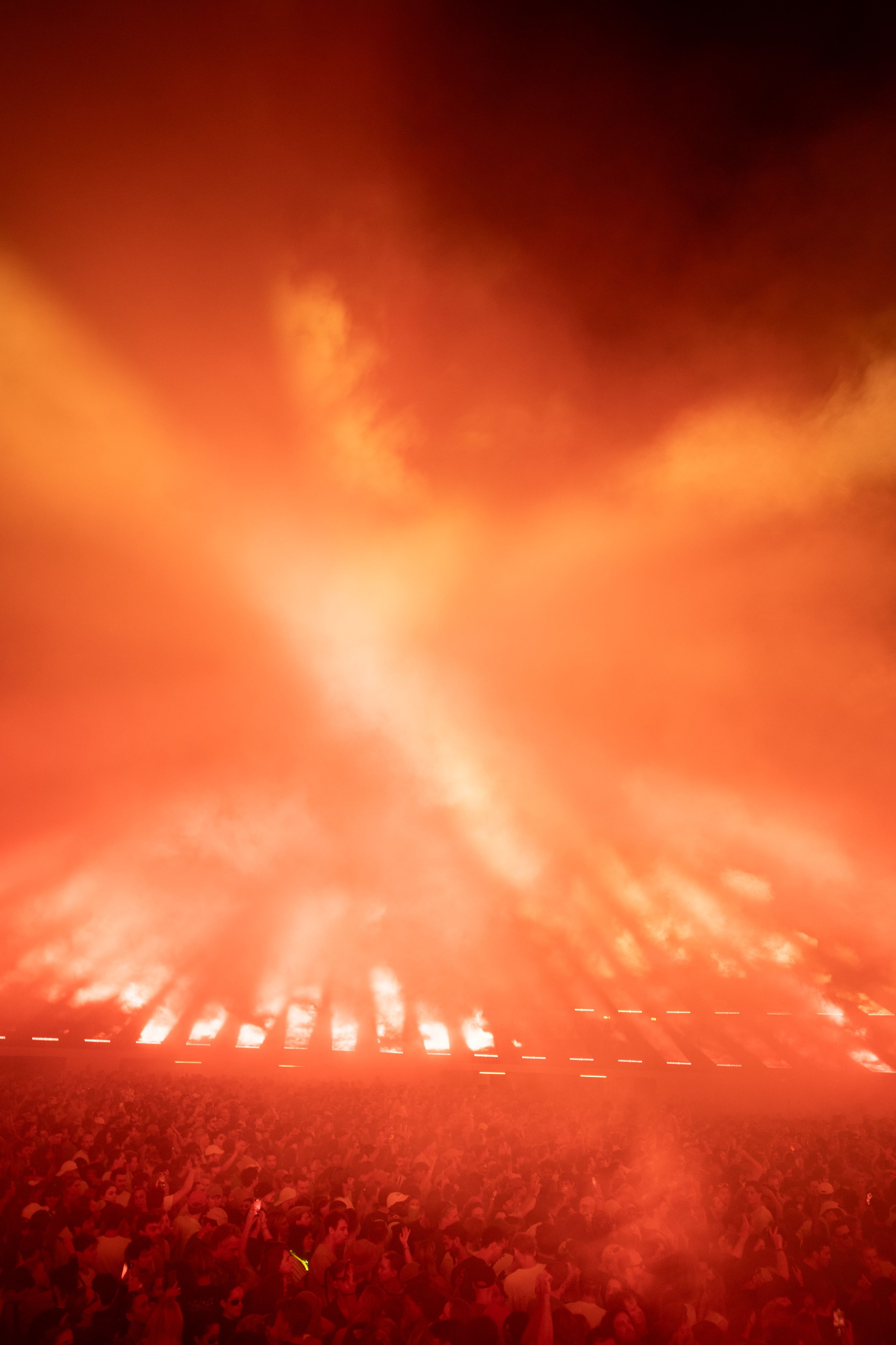 Concert crowd and stage with fiery light display and smoke effects in Dekmantel Festival.