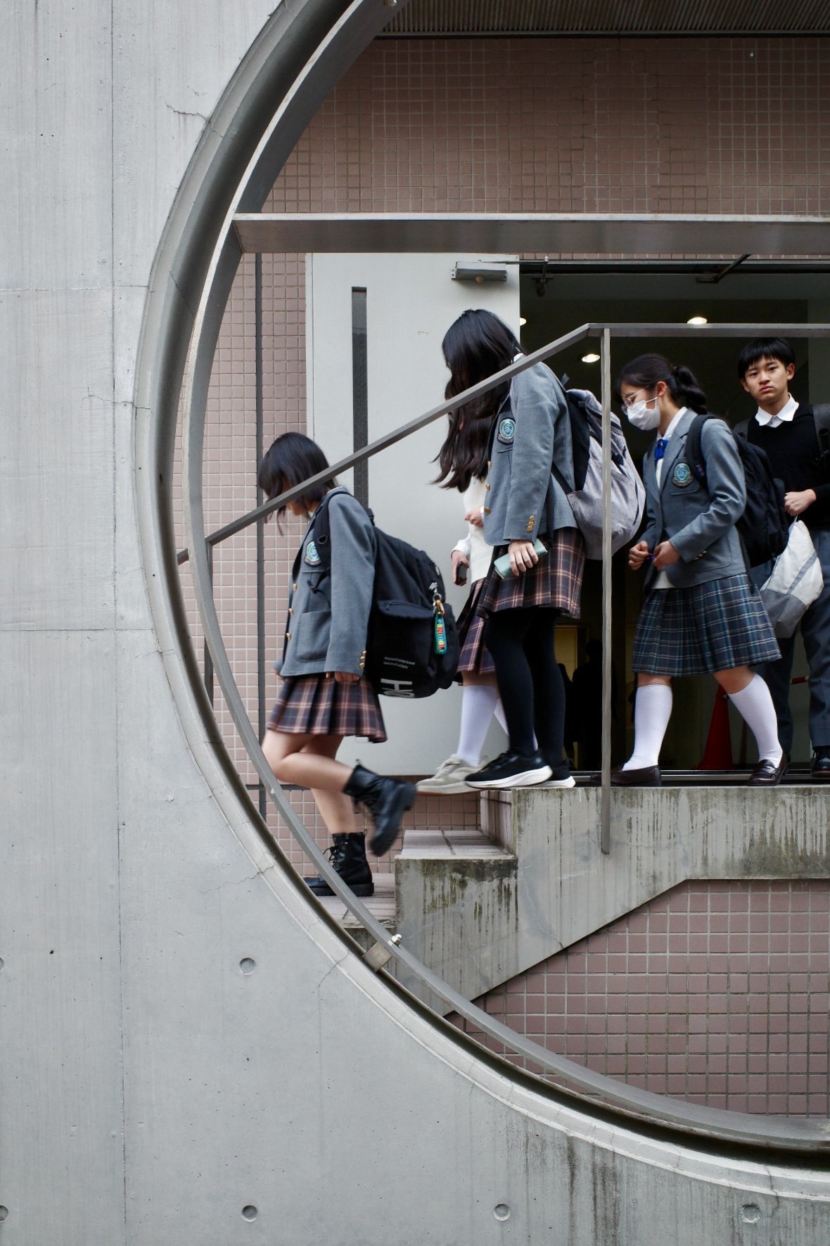 Students in school uniforms walking down stairs at school building in Tokyo, Japan.