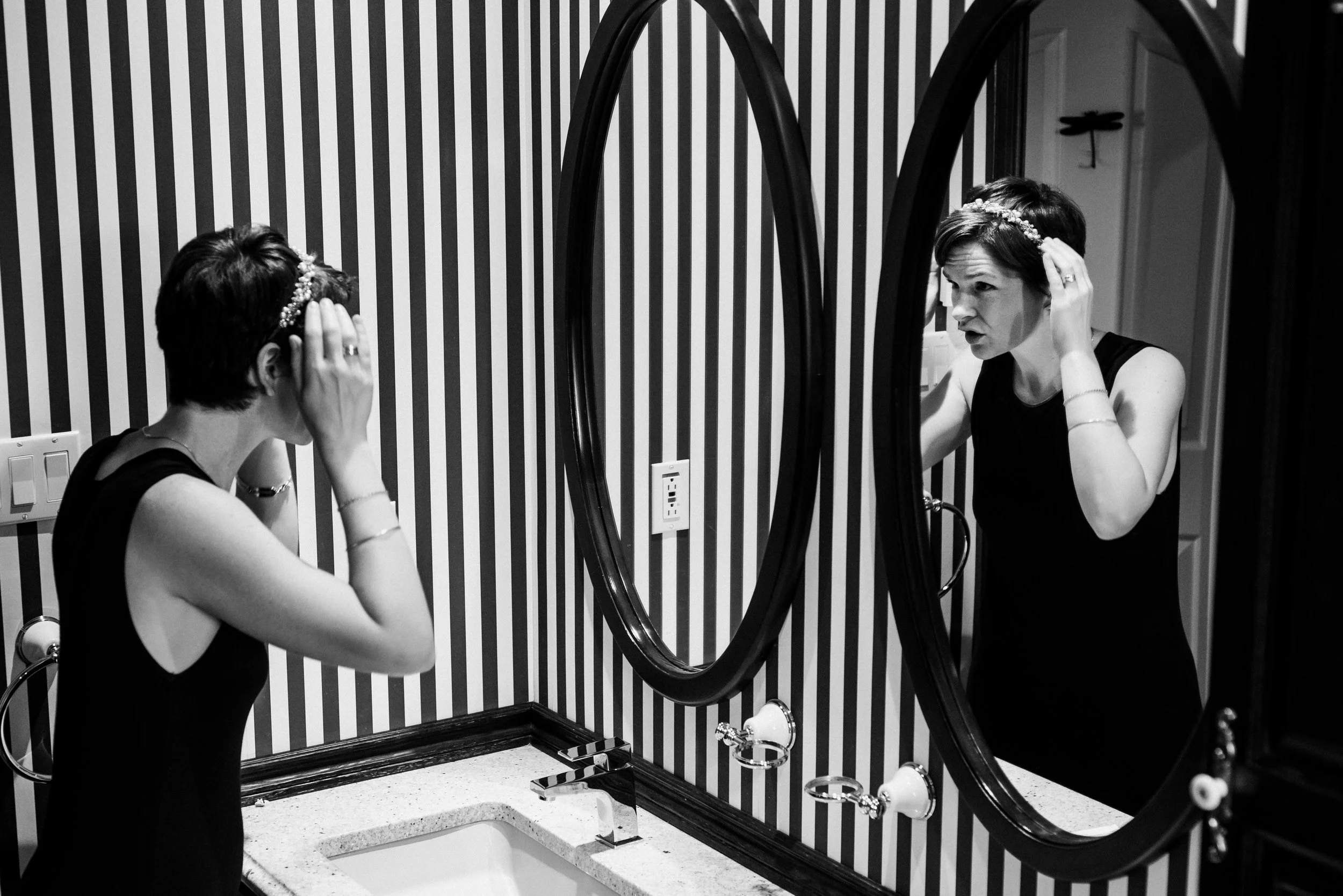 Bride arranges headband in mirror ahead of her Montreal Backyard wedding