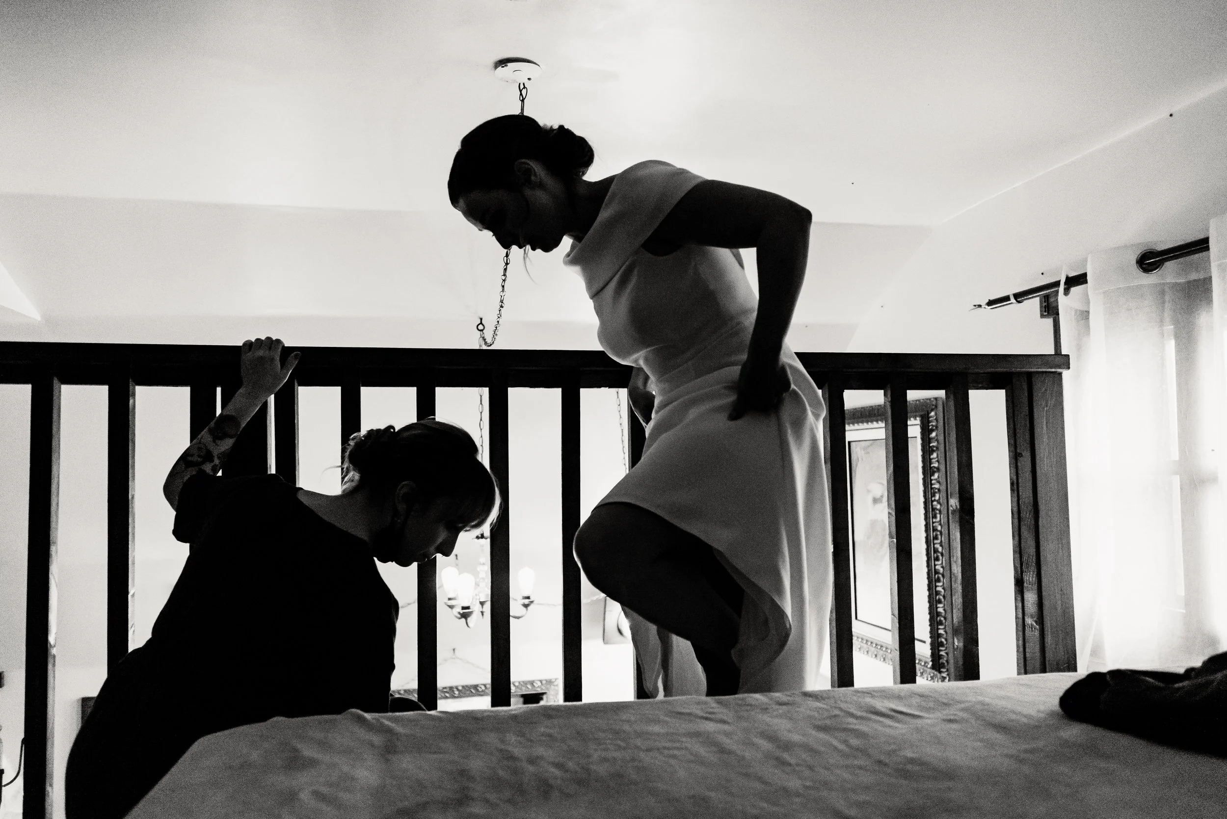 Dramatic BW Silhouette of bride's sister helping her put on shoes ahead of her Lanaudière Barn wedding ceremony