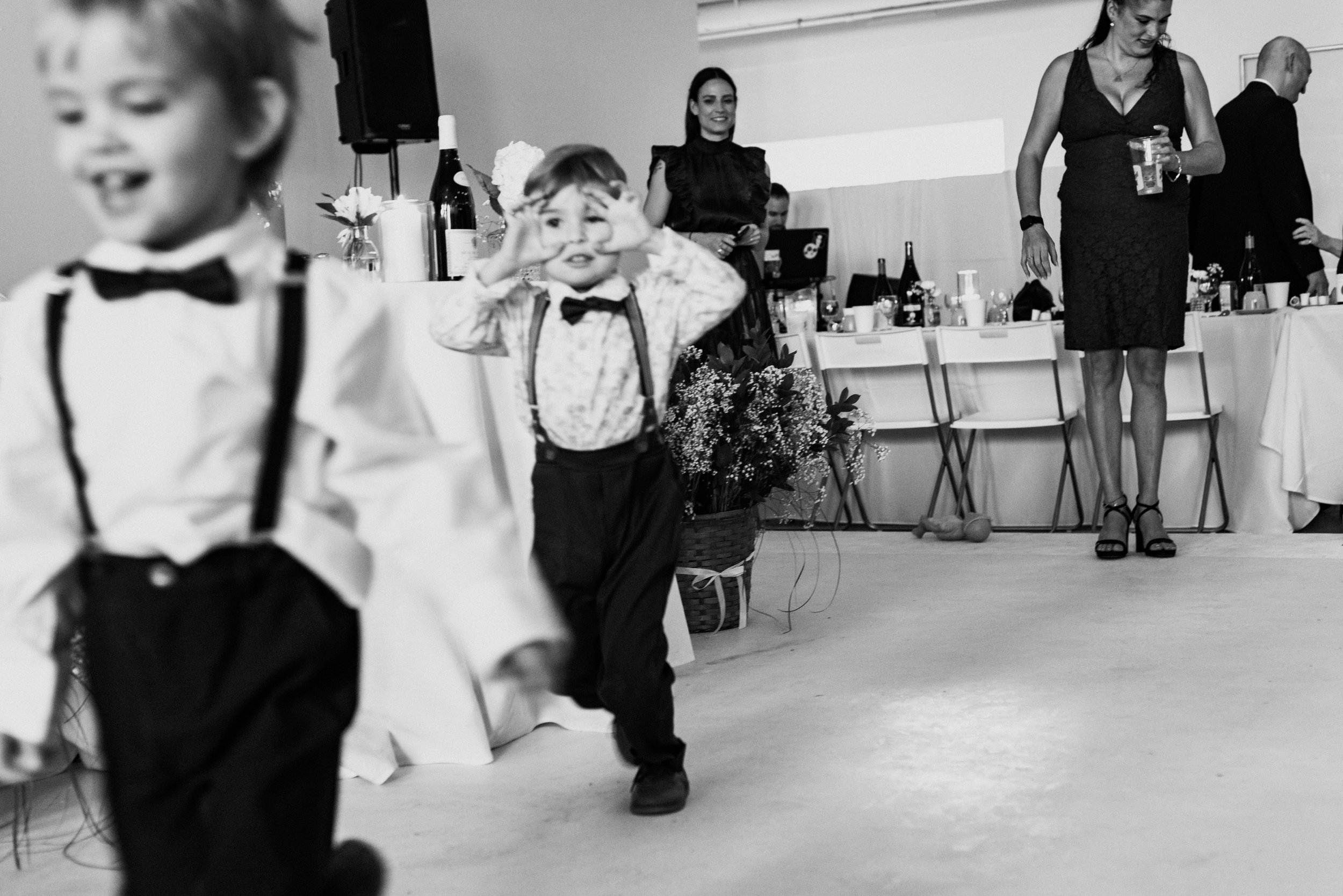 Kids in suit and bow ties running at Montreal indoor wedding ceremony