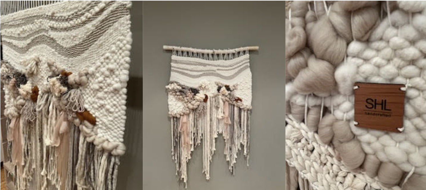 Close-up of a textured, woven wall hanging with wool yarn and fabric, featuring a wooden label 'SHL Handmade'.