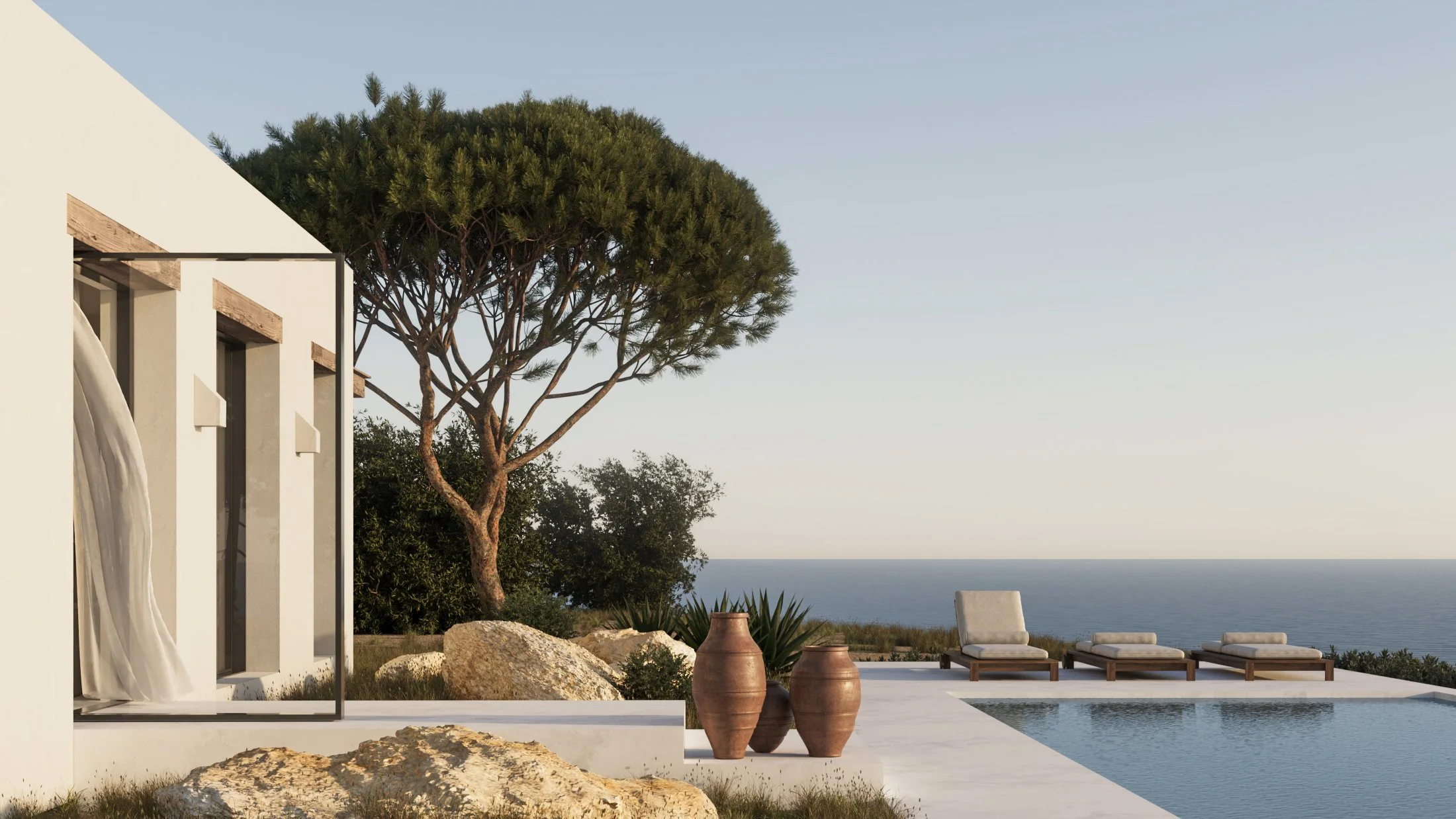 Modern white house with open glass door, overlooking a pool and outdoor seating area with lounge chairs, surrounded by large rocks, potted plants, a tall tree, and overlooking the ocean in the distance.