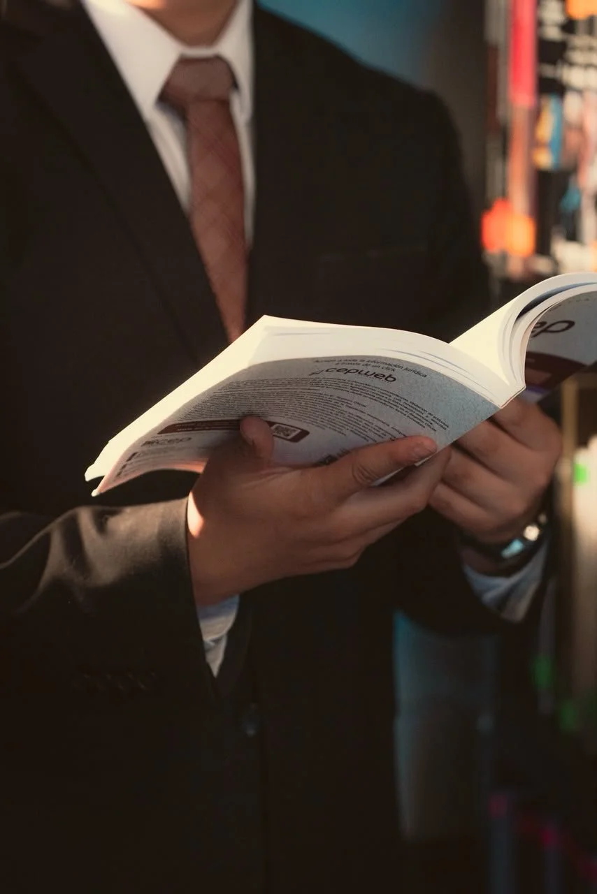 Persona con traje leyendo un libro en una librería.