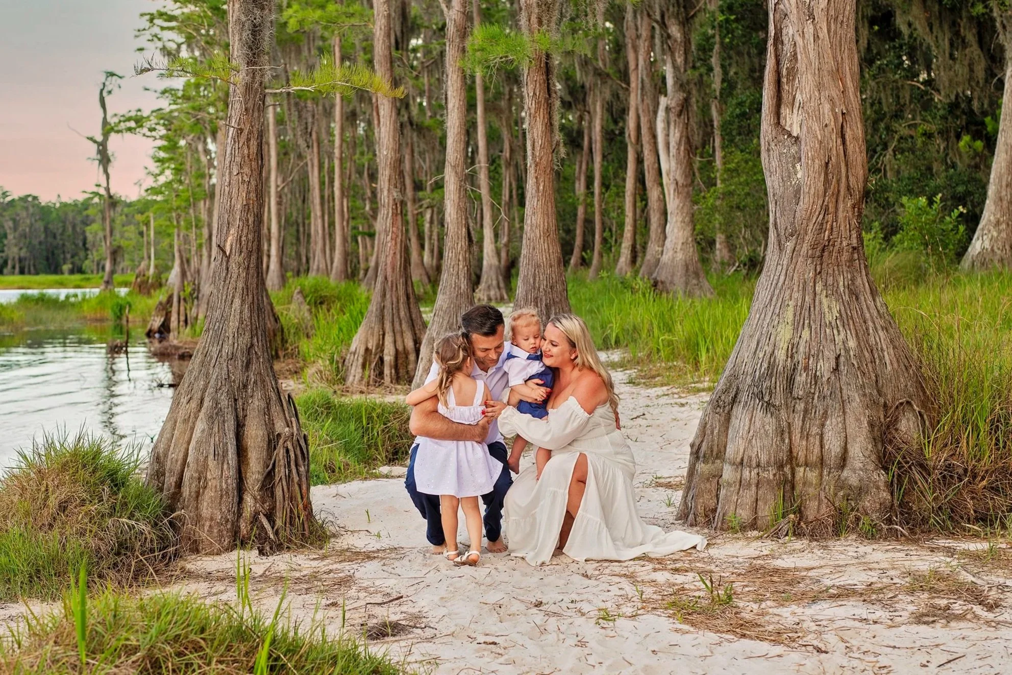 Family of 4 hugging at Lake Louisa state park Florida, cypress trees in background