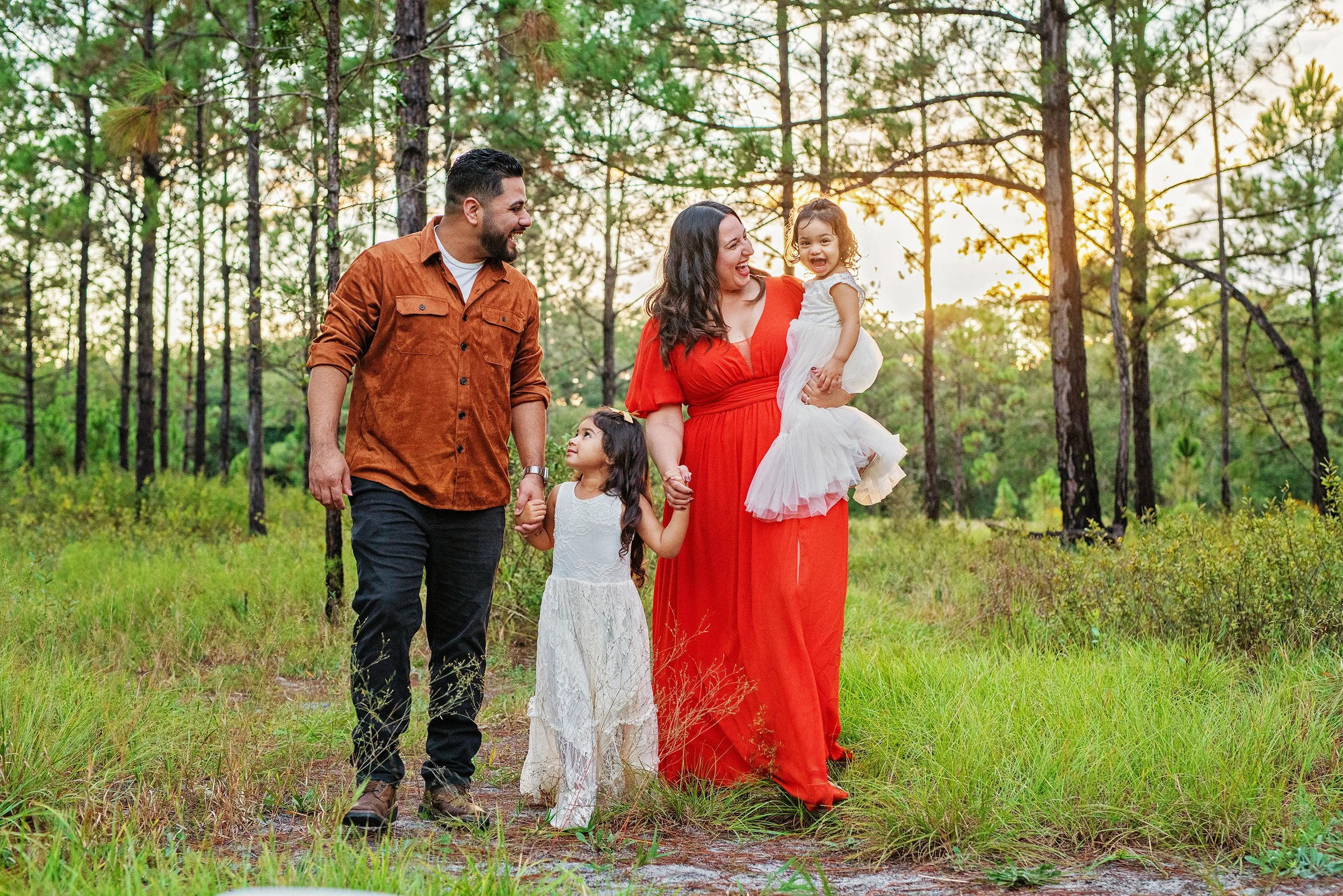 Family of 4 with 2 young girls, walking hand in hand in the forest at Lake Louisa State park
