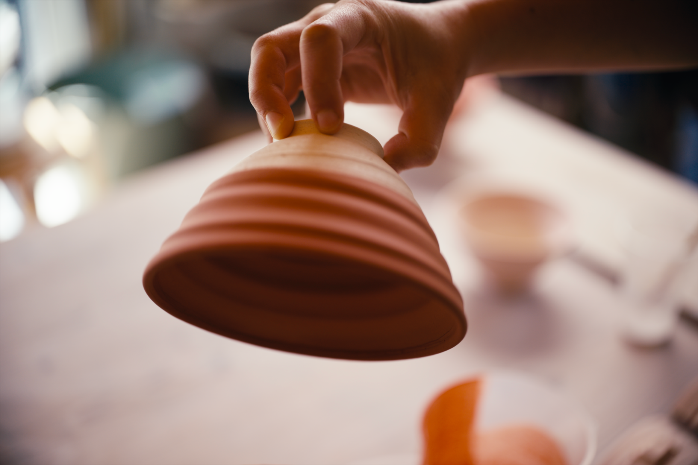 Close-up of a hand stacking or aligning colored clay or ceramic pieces.