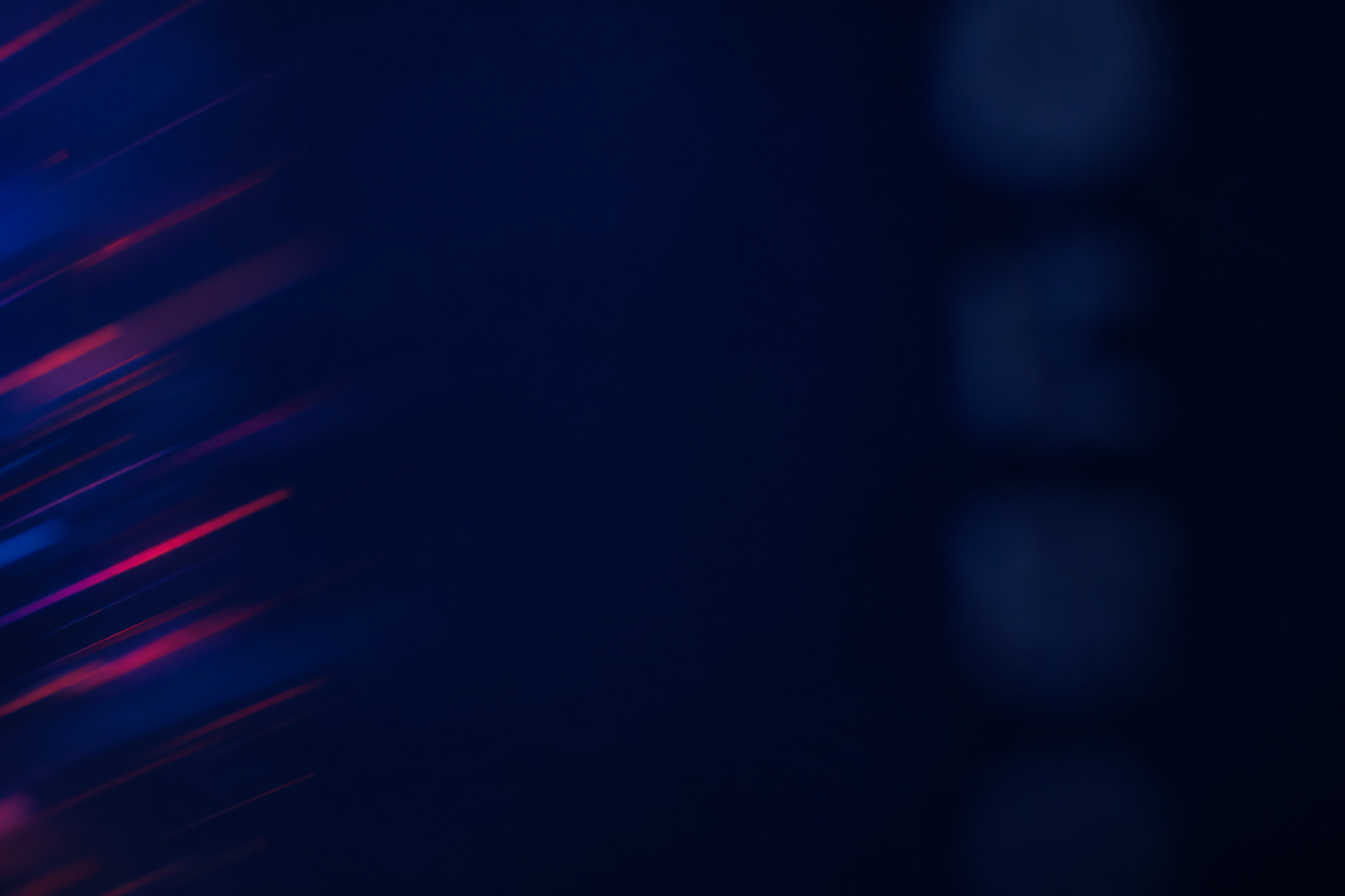 Abstract image with dark background and diagonal streaks of blue and red light.