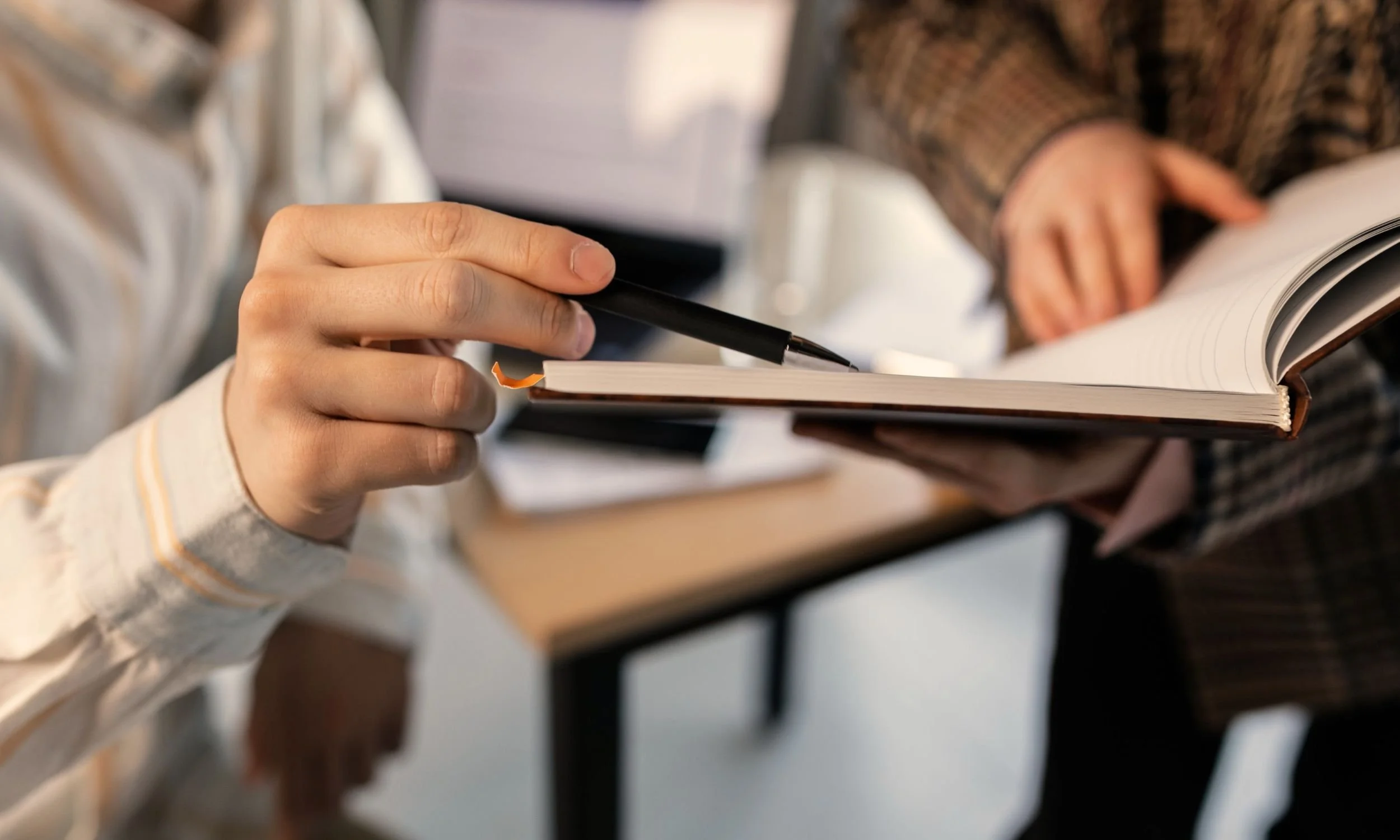 Close-up of a student signing scholarship paperwork for a foundation for excellence in education, highlighting educational opportunities and mentorship programs.