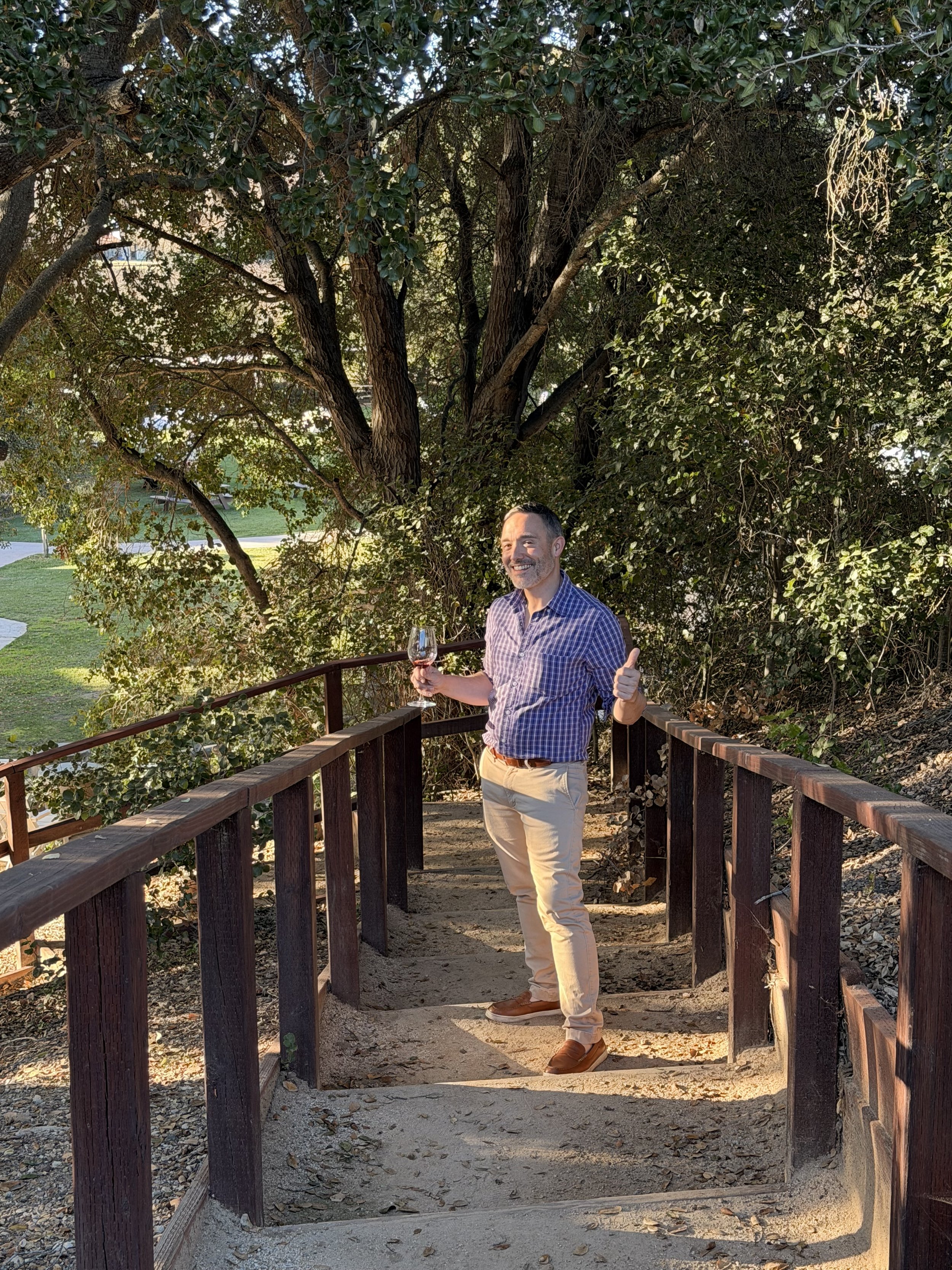 Michael enjoying a glass of wine outdoors at a vineyard