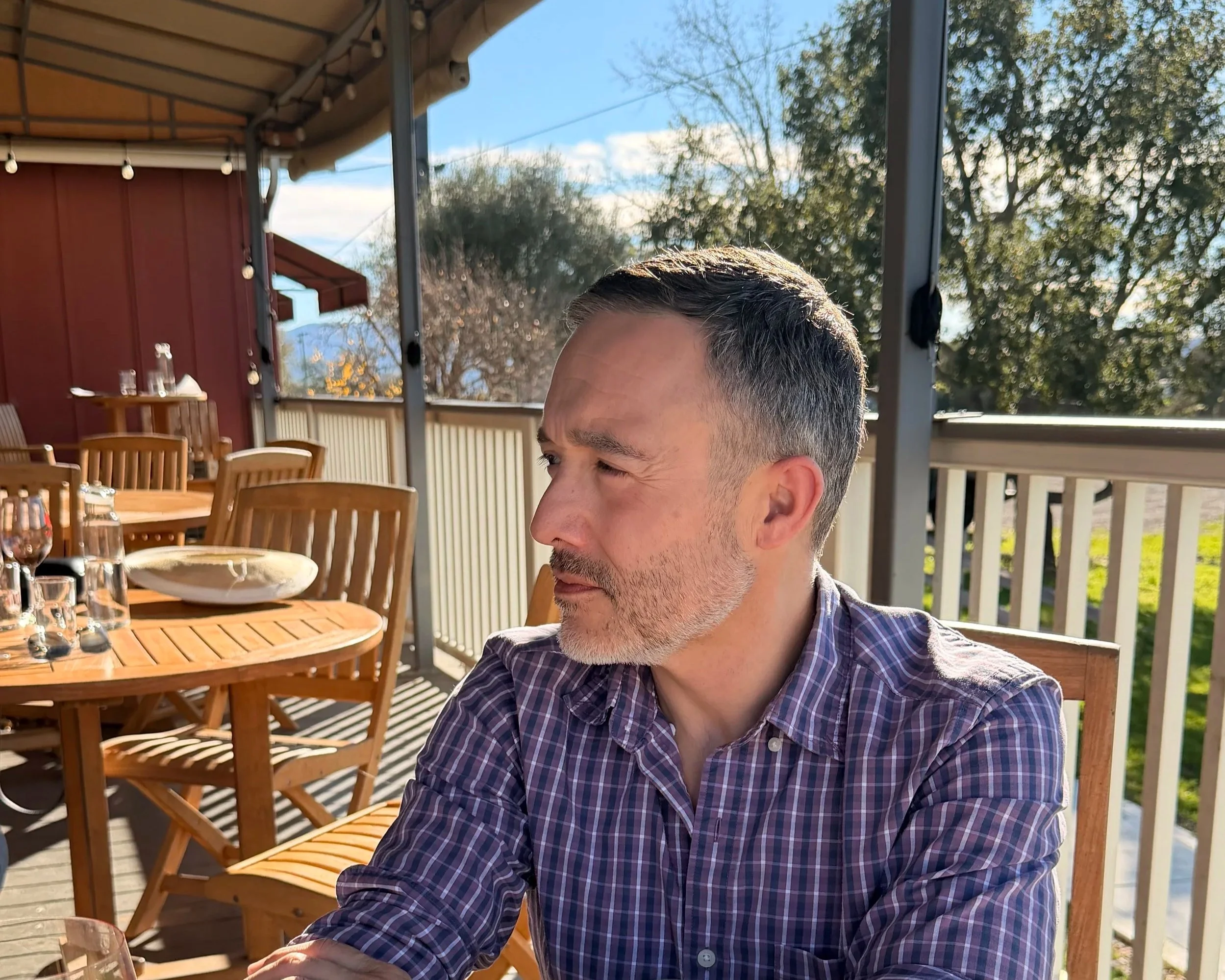 Michael wine tasting on a sunny vineyard patio