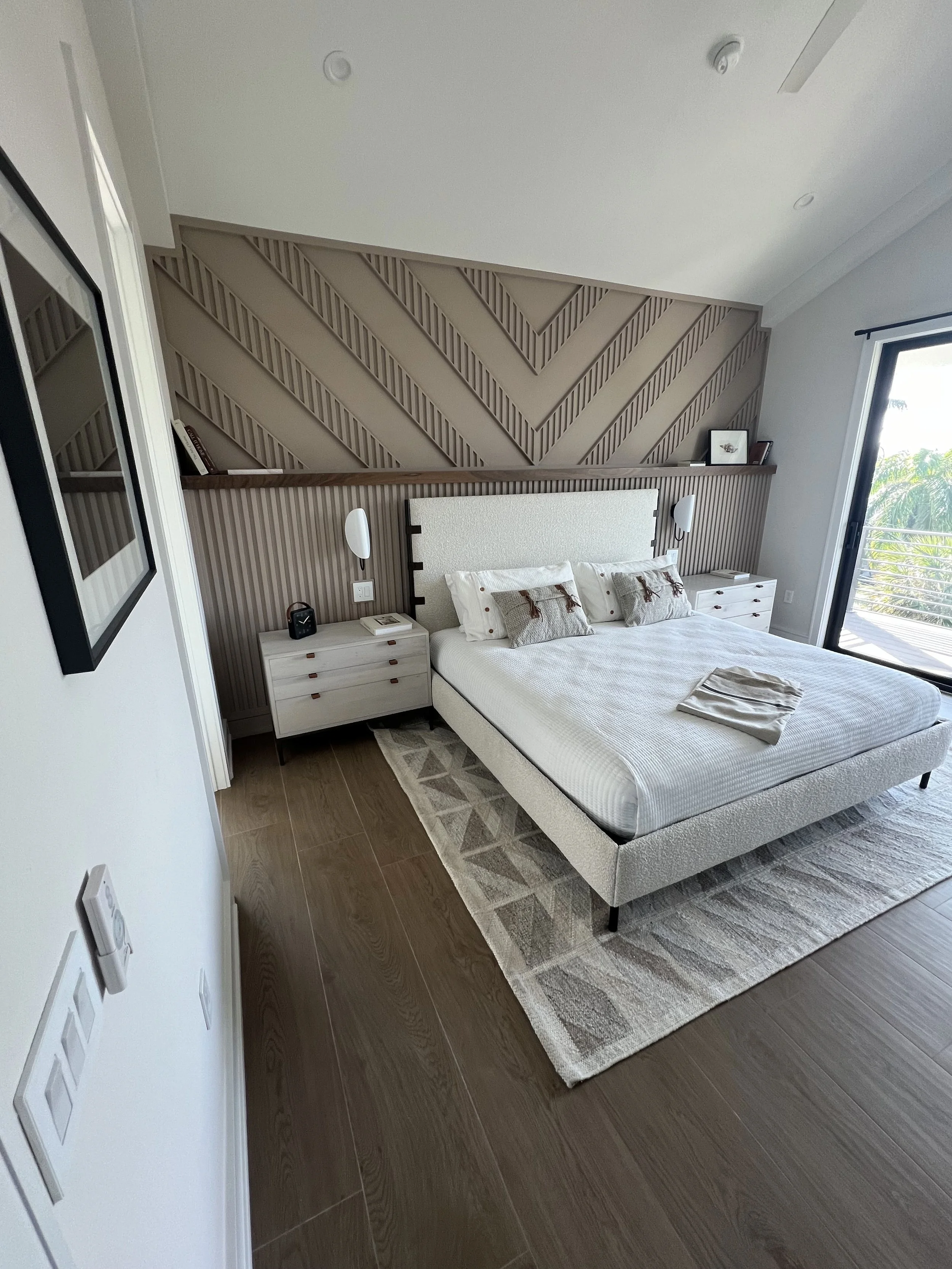 Chevron wood accent wall behind the bed — Project 08.