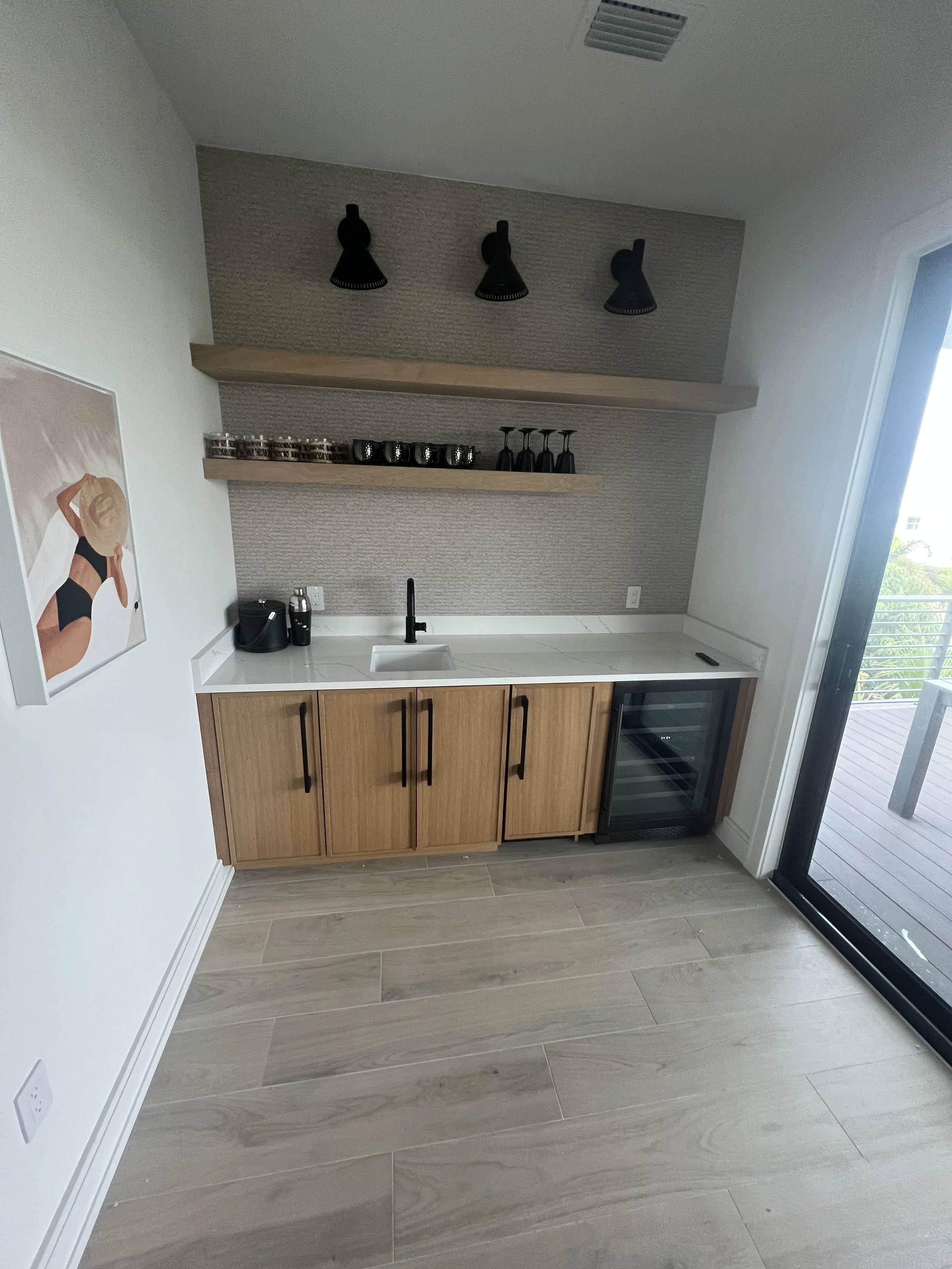 Compact kitchenette with wood cabinetry and floating shelves — Project 02.
