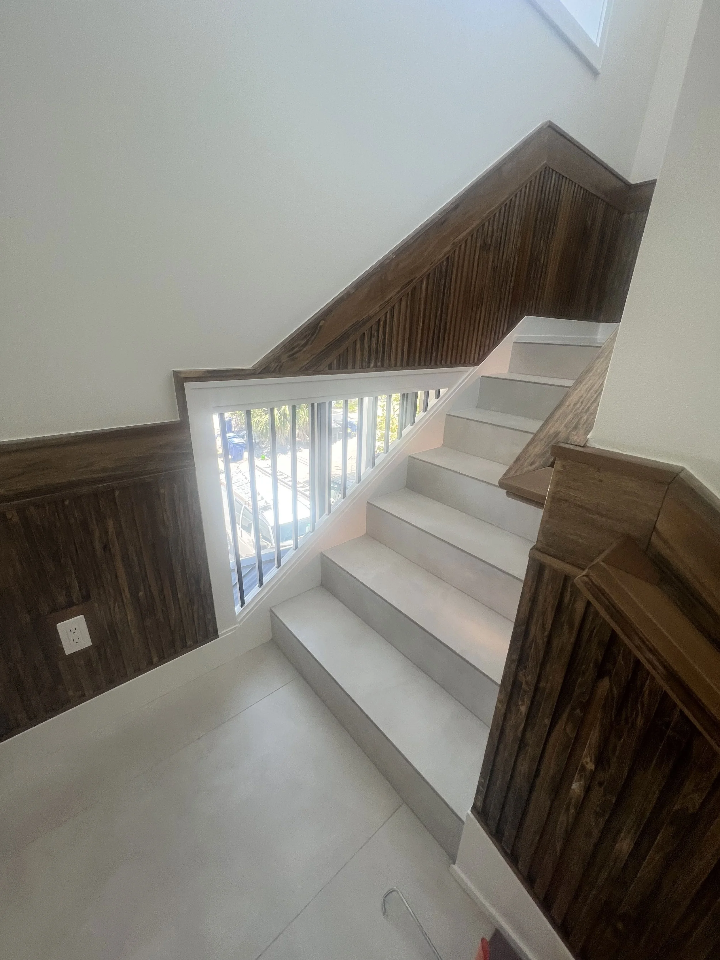 Staircase with wood wall paneling and railing — Project 01.