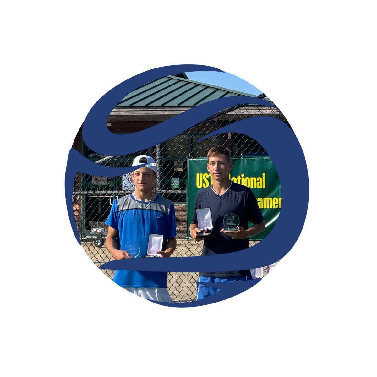 Two teenage boys standing on a tennis court holding awards, with a green banner in the background that reads "USTA National".