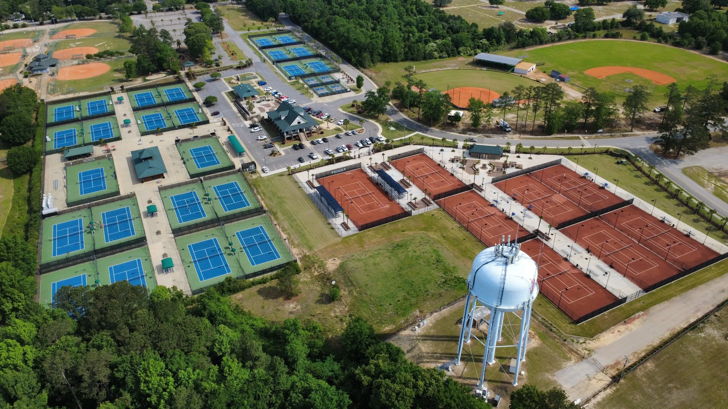 Aerial view of tennis courts surrounded by trees.