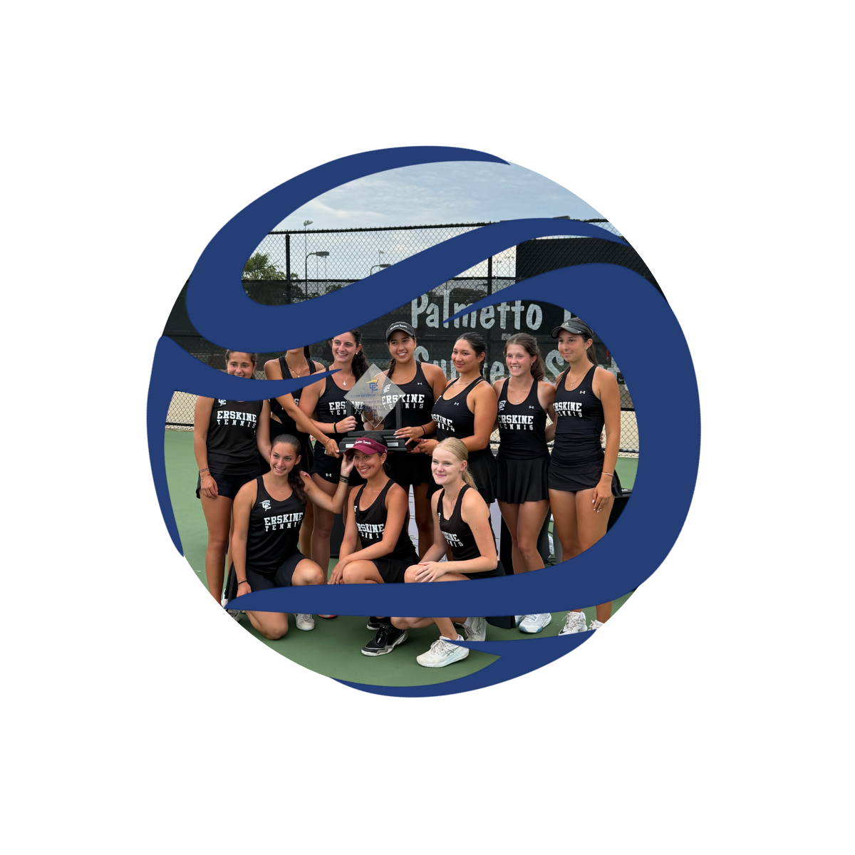A group of female tennis players from Erskine Tennis team posing on a tennis court, some holding a trophy, with a fence and the Palmetto sign in the background.