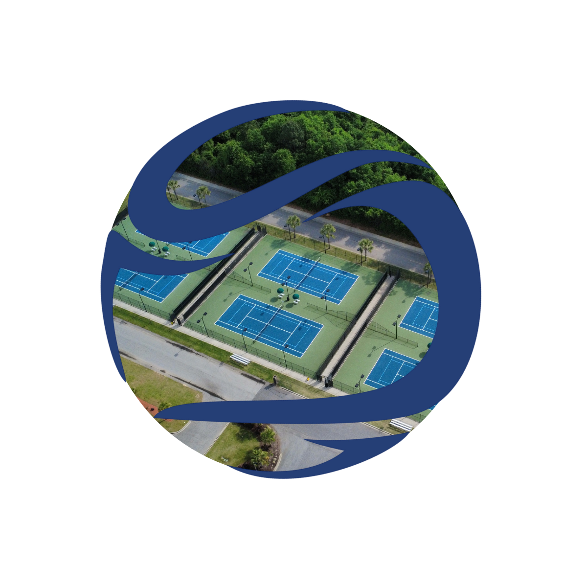 Aerial view of multiple blue tennis courts with surrounding green fencing, trees, and scenic landscape.