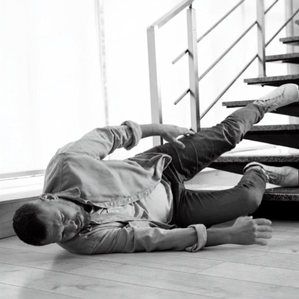 Person falling down the stairs caught by another person on the floor.