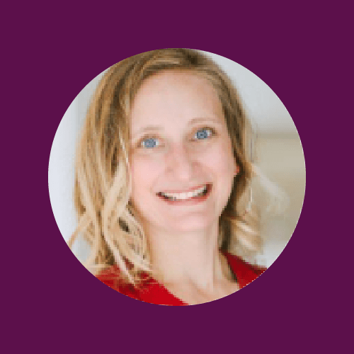A woman with blonde curly hair smiling, wearing a red top, against a purple background.