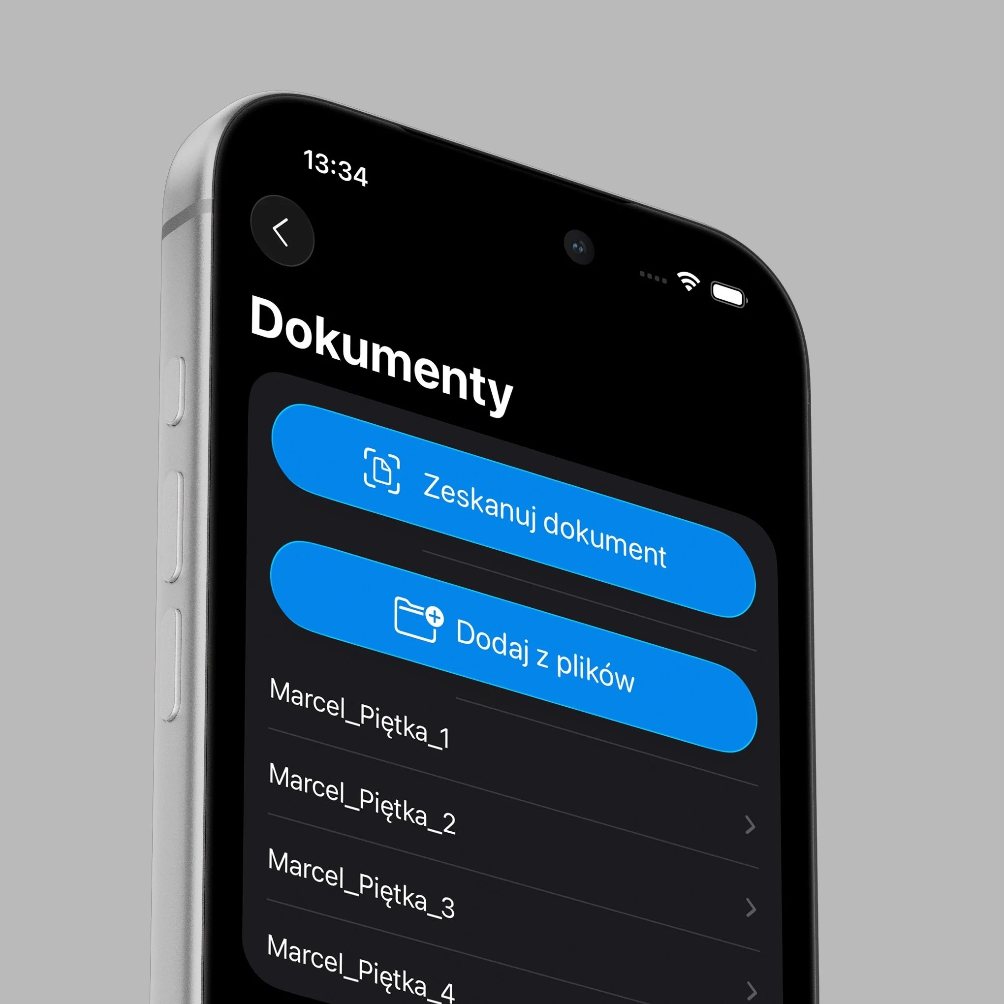 Close-up of a smartphone screen displaying document scanning app interface with text in Polish, showing options to scan documents and add files, with the time 13:34 and battery indicator visible.