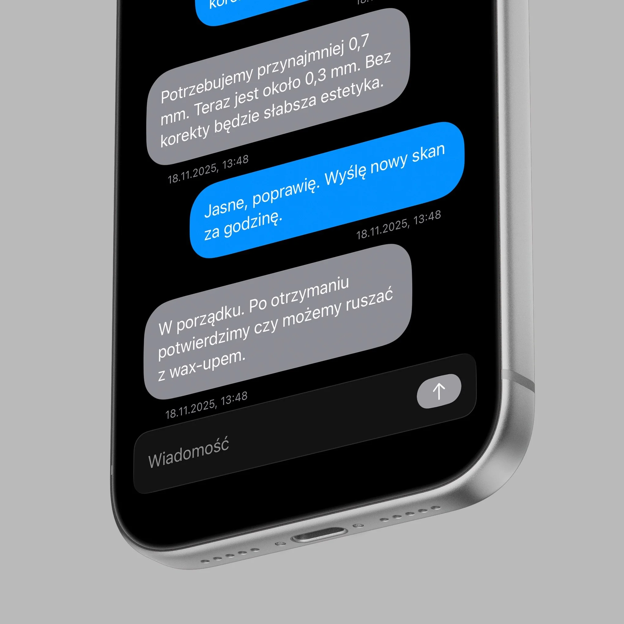 Close-up of a smartphone screen displaying a conversation in Polish, with gray and blue message bubbles.