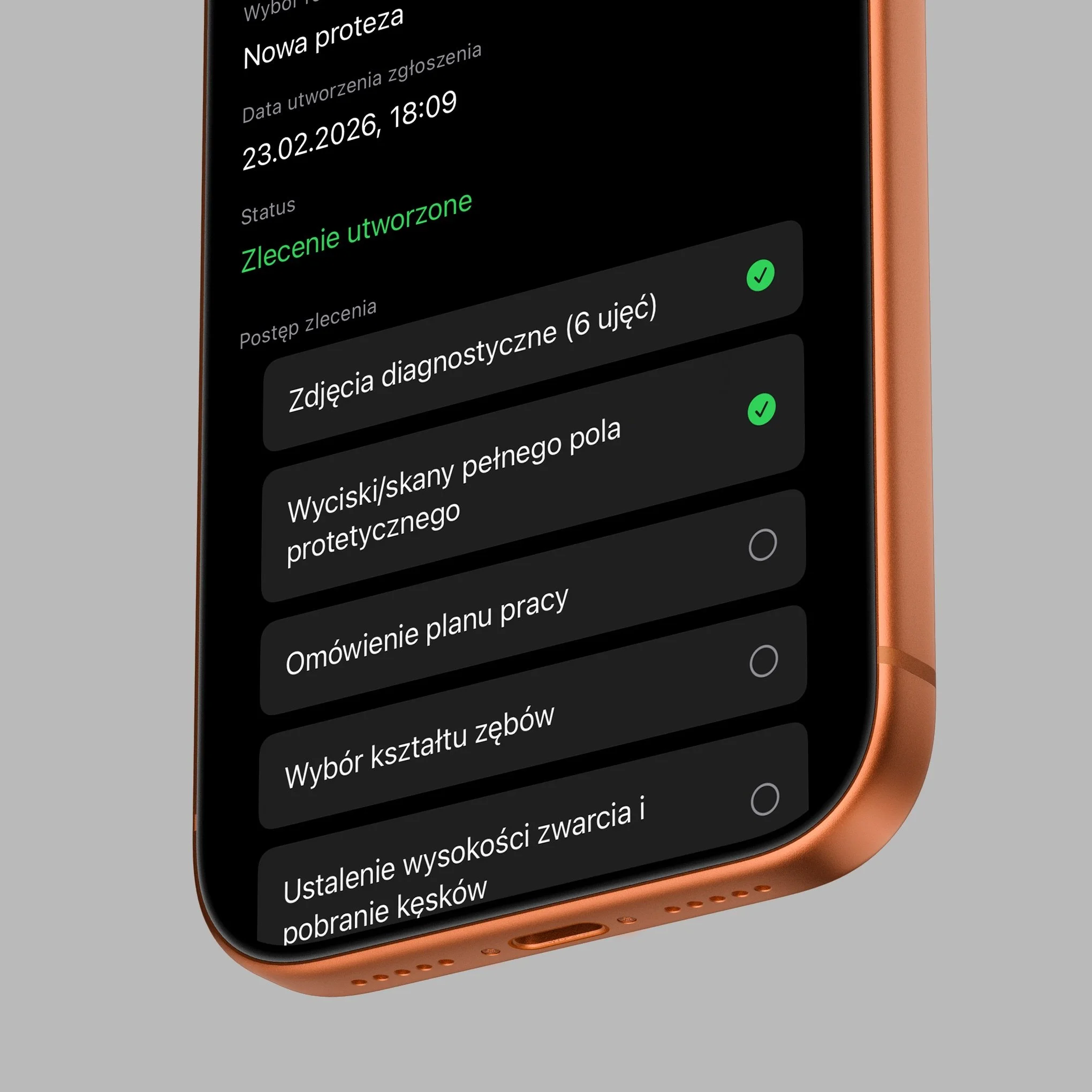 Close-up view of a smartphone screen displaying text in Polish, with a black background and green highlights, set in a rose gold-colored phone frame.
