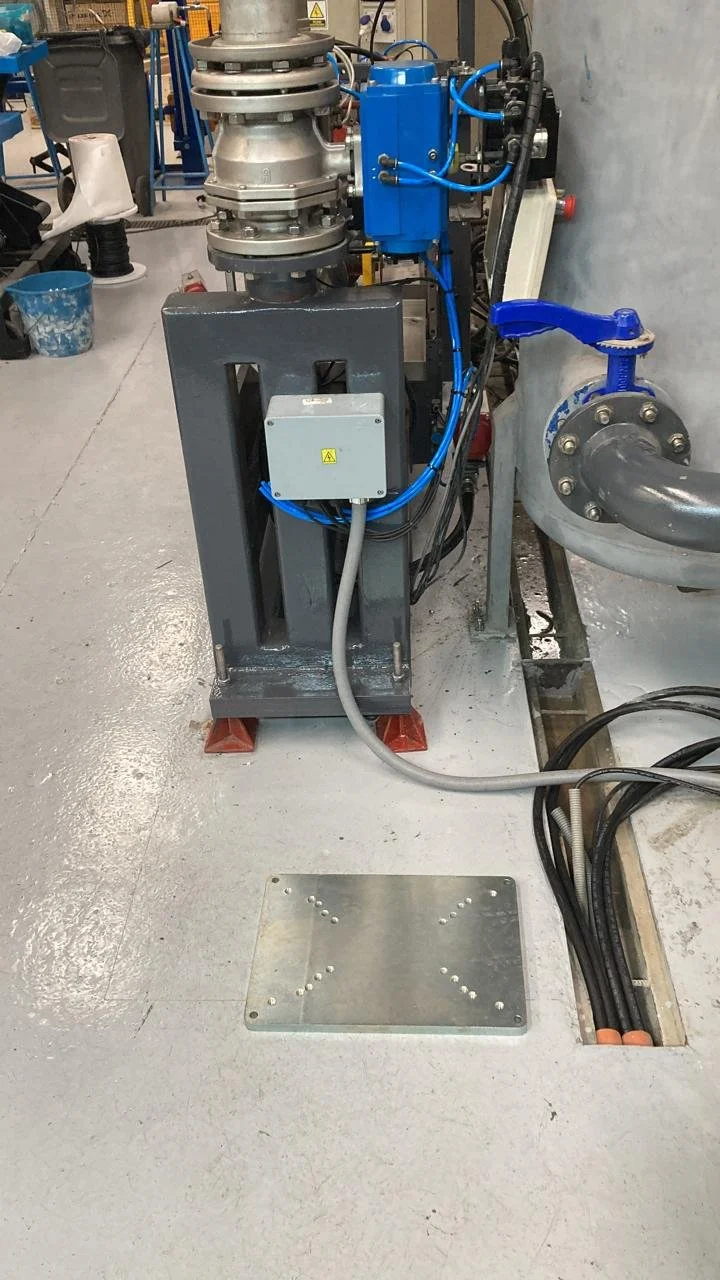 Equipo industrial con tuberías y conexiones en un entorno de fábrica o laboratorio.