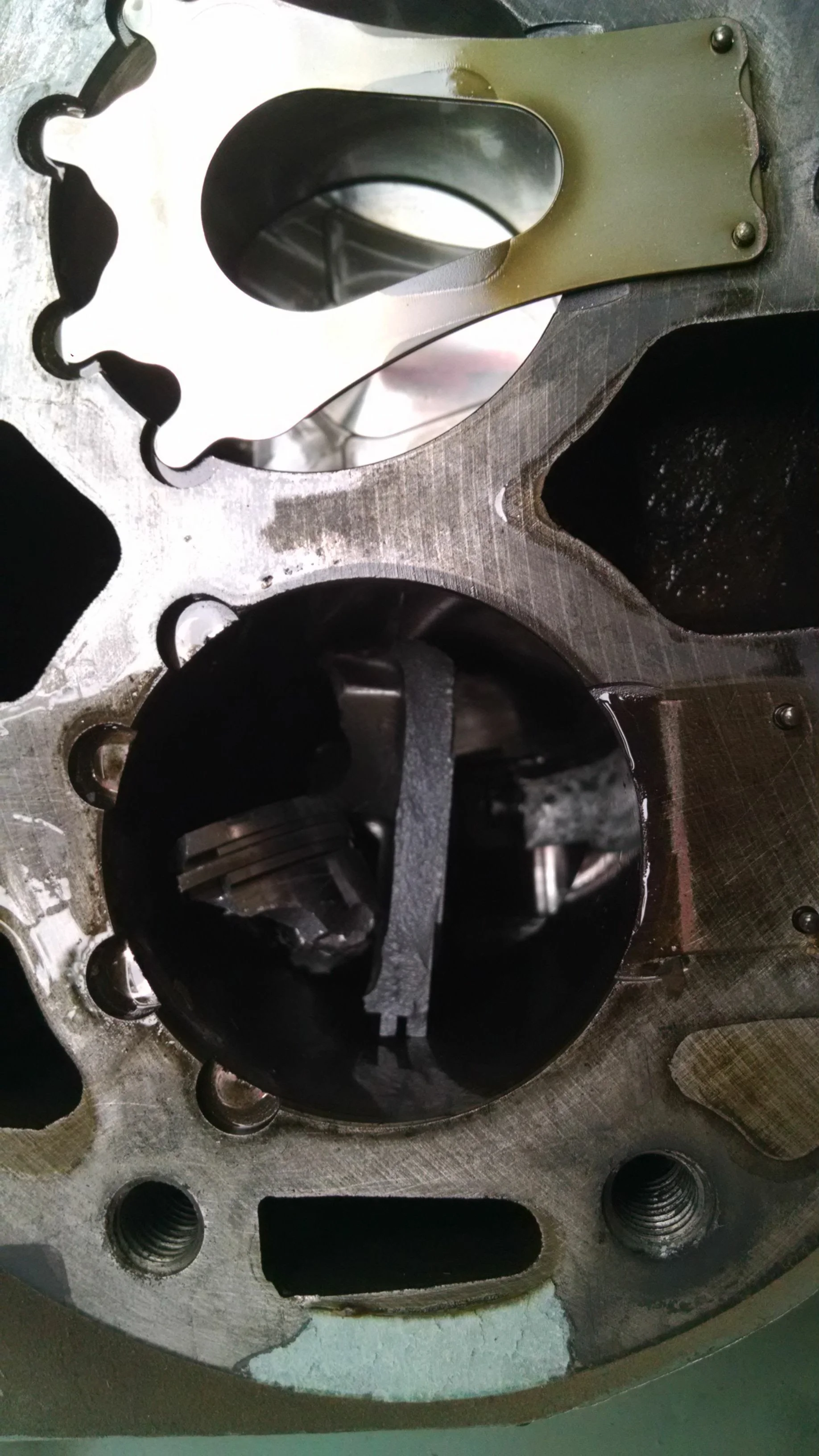 Vista del interior de un cilindro de motor de combustión interna, mostrando el bloque del cilindro, los pistones y componentes internos.