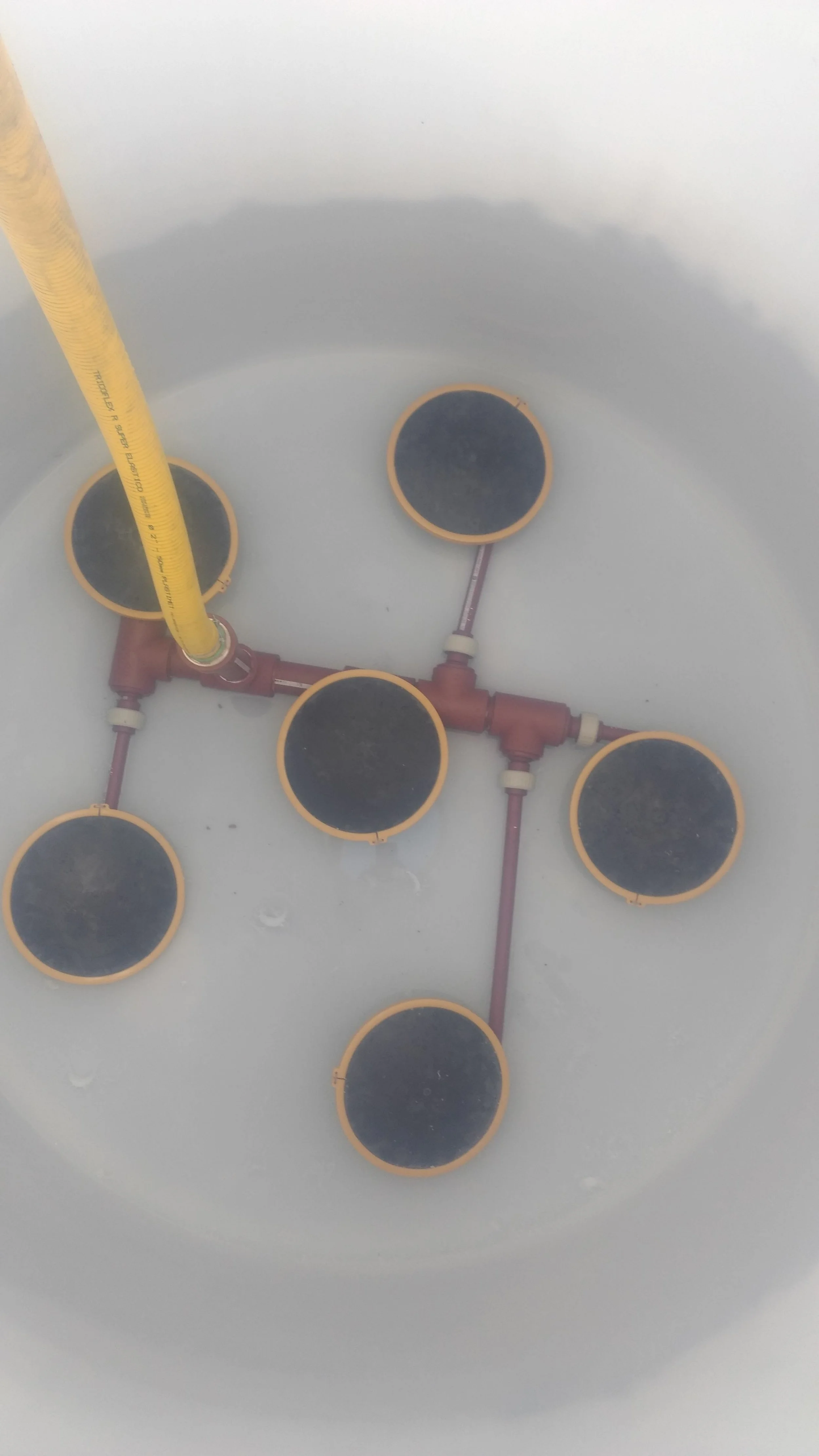Sistema de tuberías y cesteras en un fondo blanco, probablemente en una instalación o proceso industrial.