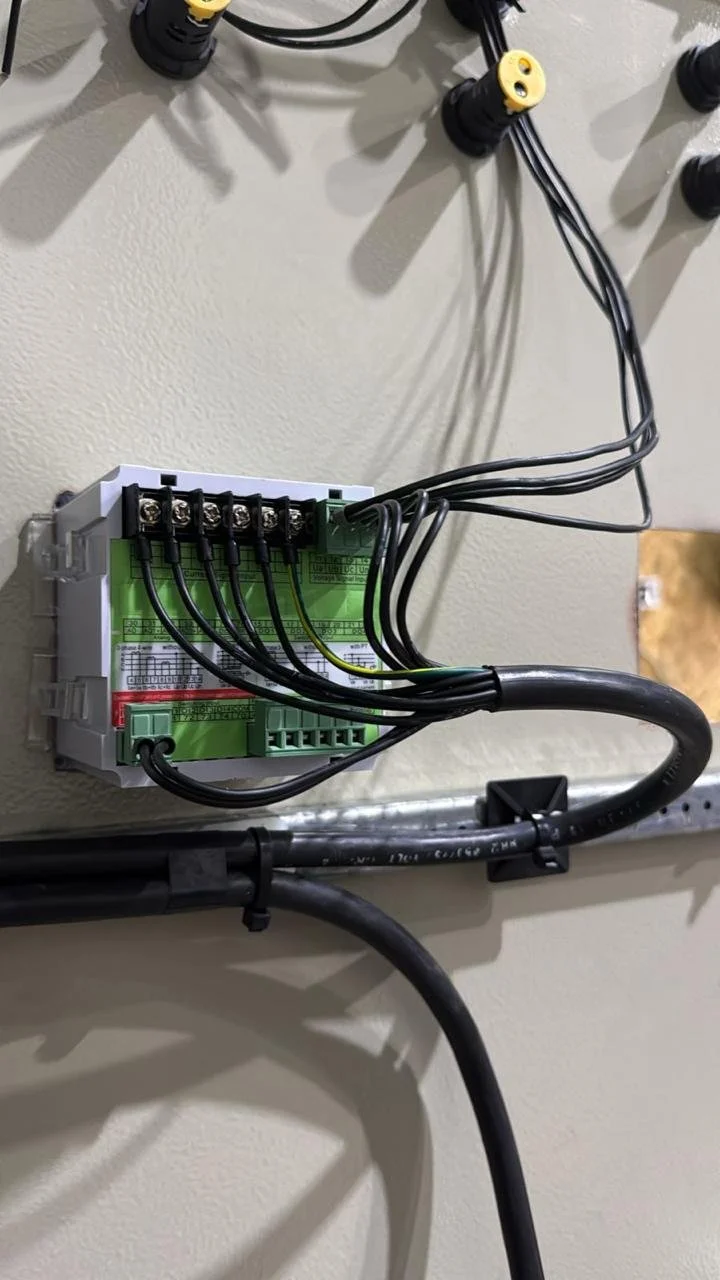 Caja de conexiones eléctricas con cables conectados, instalada en la pared.