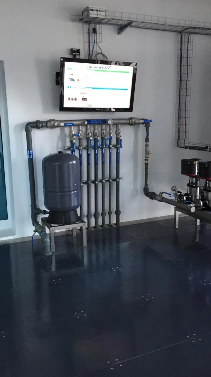 Sistema de filtración de agua con bombas y tuberías de metal en un ambiente industrial