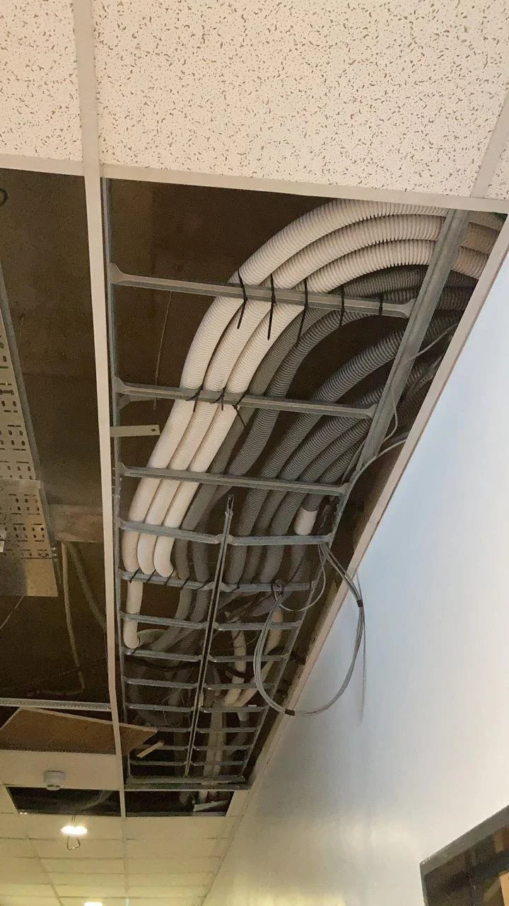 Cables de electricidad y datos en un techo suspendido en construcción o mantenimiento.