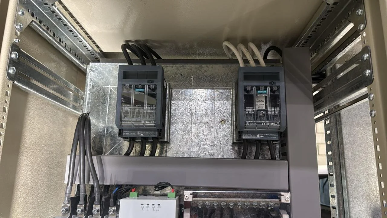 Panel eléctrico con dos contactores, cables conectados y una caja de distribución.