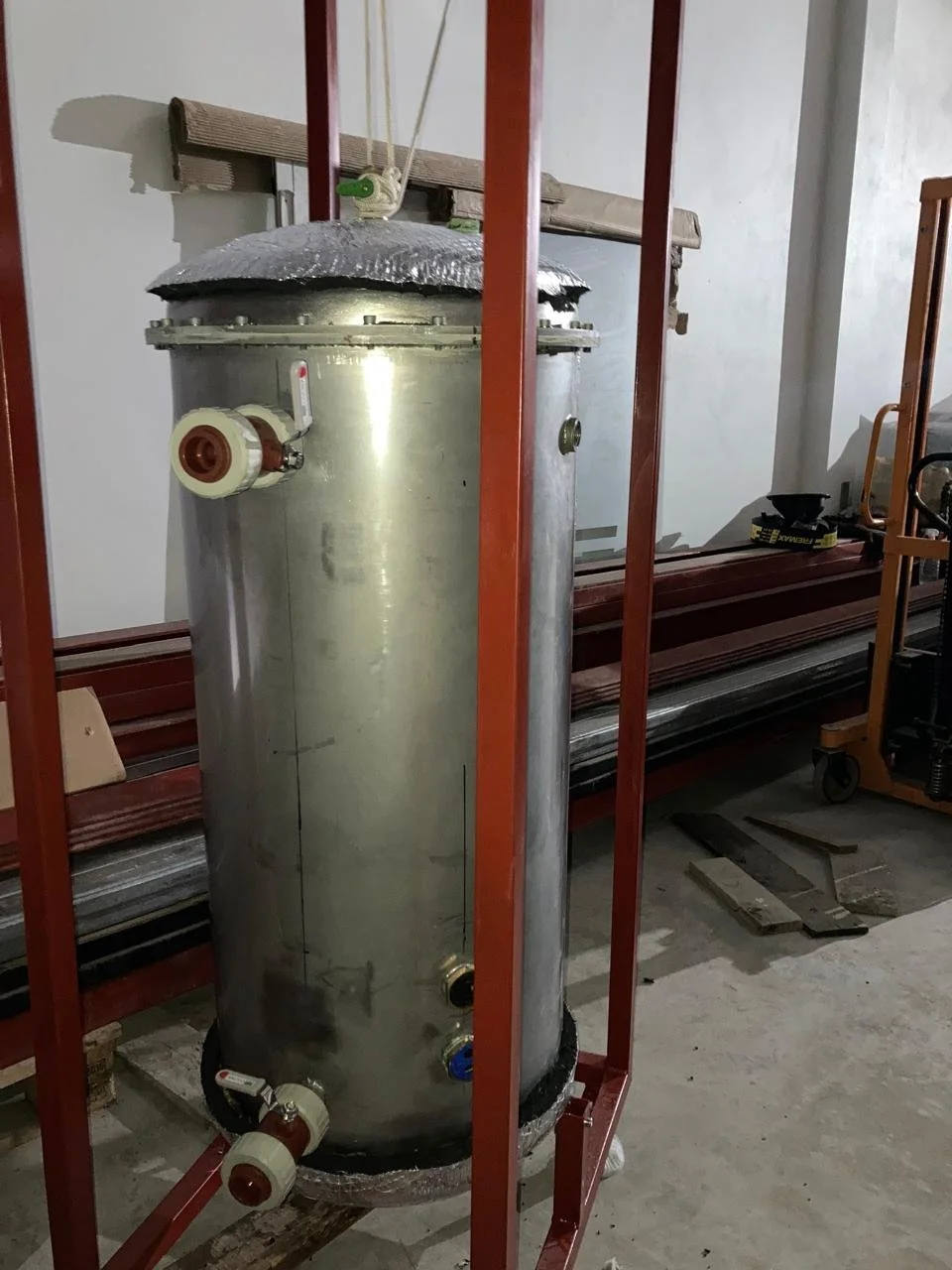 Tanque horizontal de acero inoxidable con conexiones y valvulas, parte de un sistema de almacenamiento o proceso industrial.