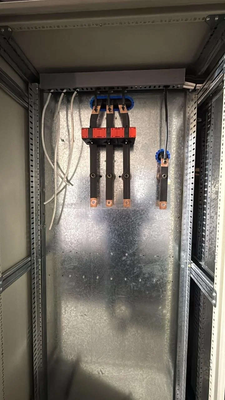 Interior de un cuadro eléctrico con componentes eléctricos y cables sin conectar.