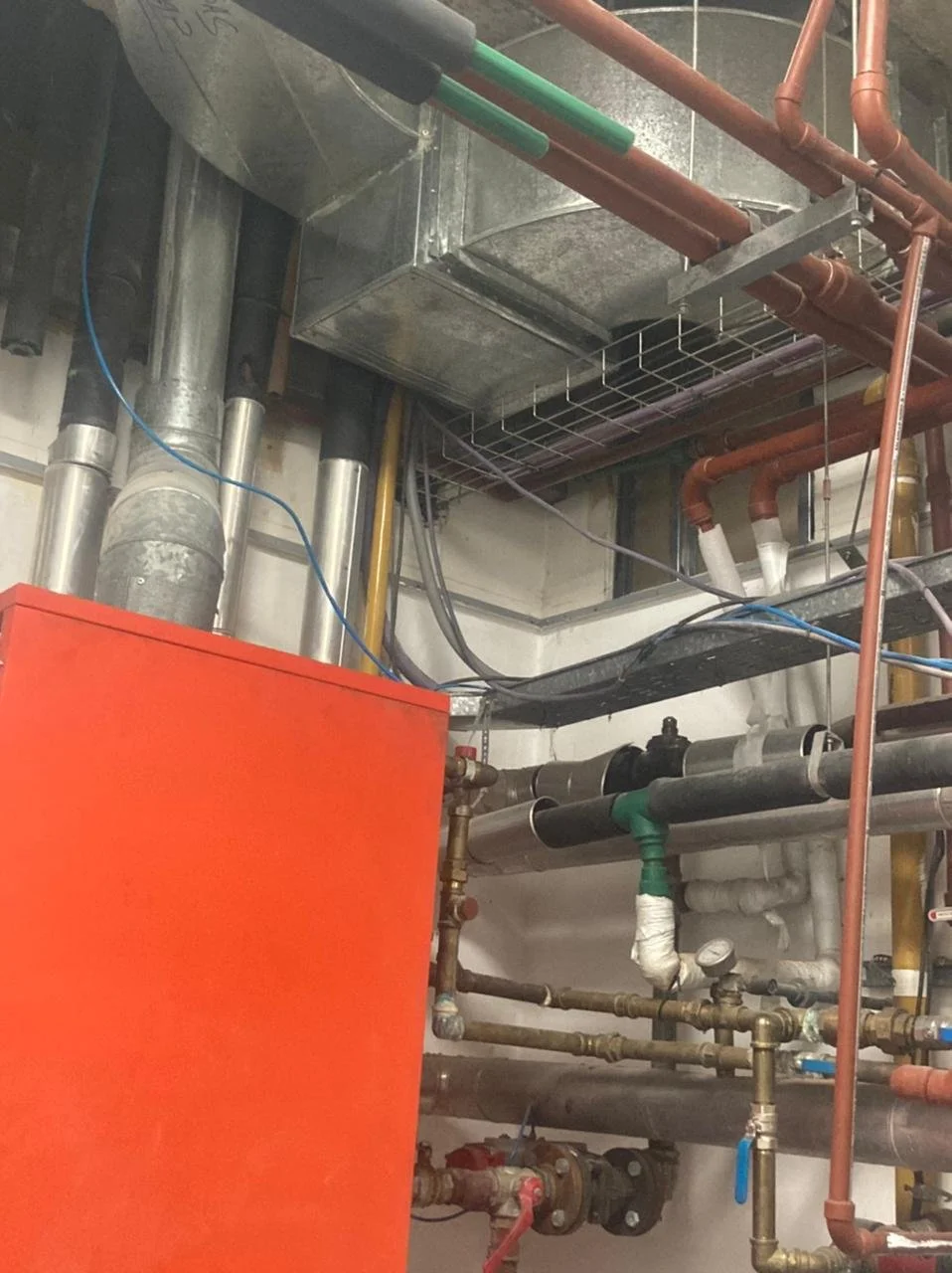 Sistema de tuberías y maquinaria en un espacio industrial o técnico.