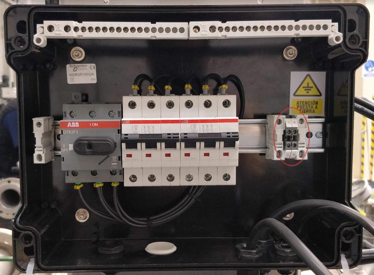 Panel eléctrico con varios interruptores, conexiones y advertencias de seguridad.