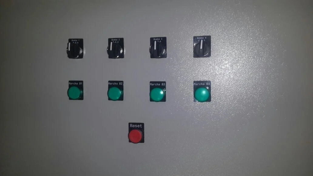 Panel de control con cuatro interruptores negros indicados como Bomba 1 a Bomba 4, y cuatro botones verdes etiquetados como Marcha B1 a B4, además de un botón rojo etiquetado Reset.